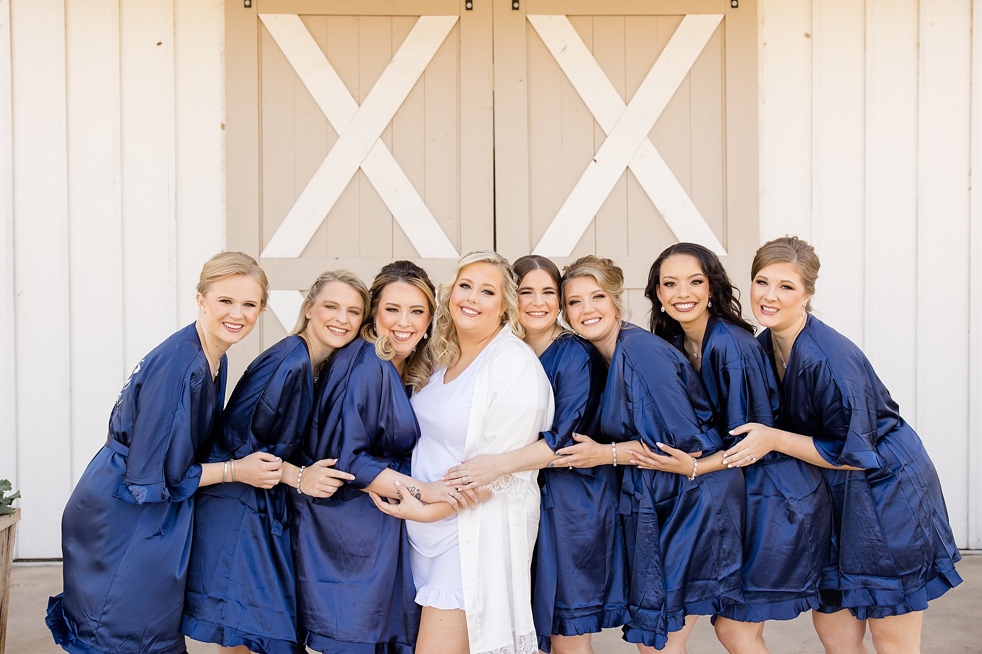 bride poses with bridesmaids in matching blue robes