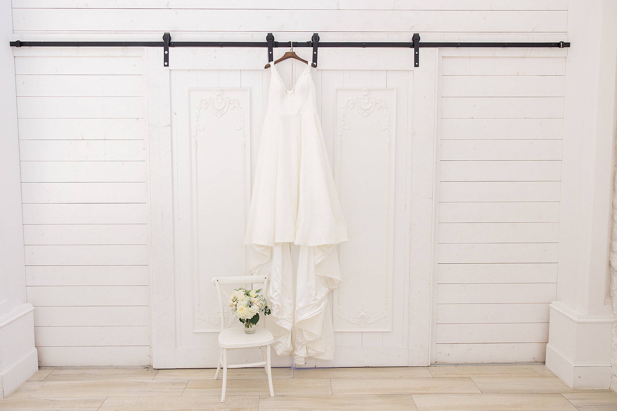 bride's dress hangs on door before