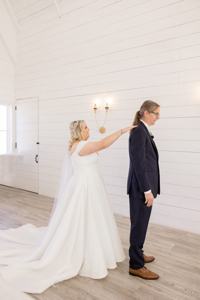 bride taps dad's shoulders for first look at the Nest at Ruth Farms