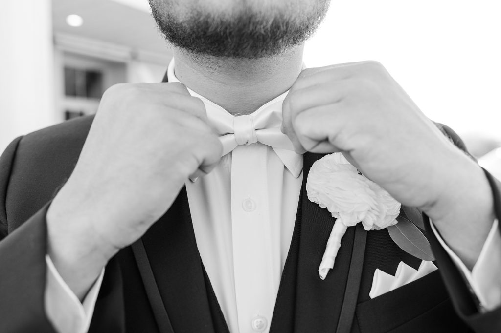 groom adjusts tie before fall wedding in Dallas TX