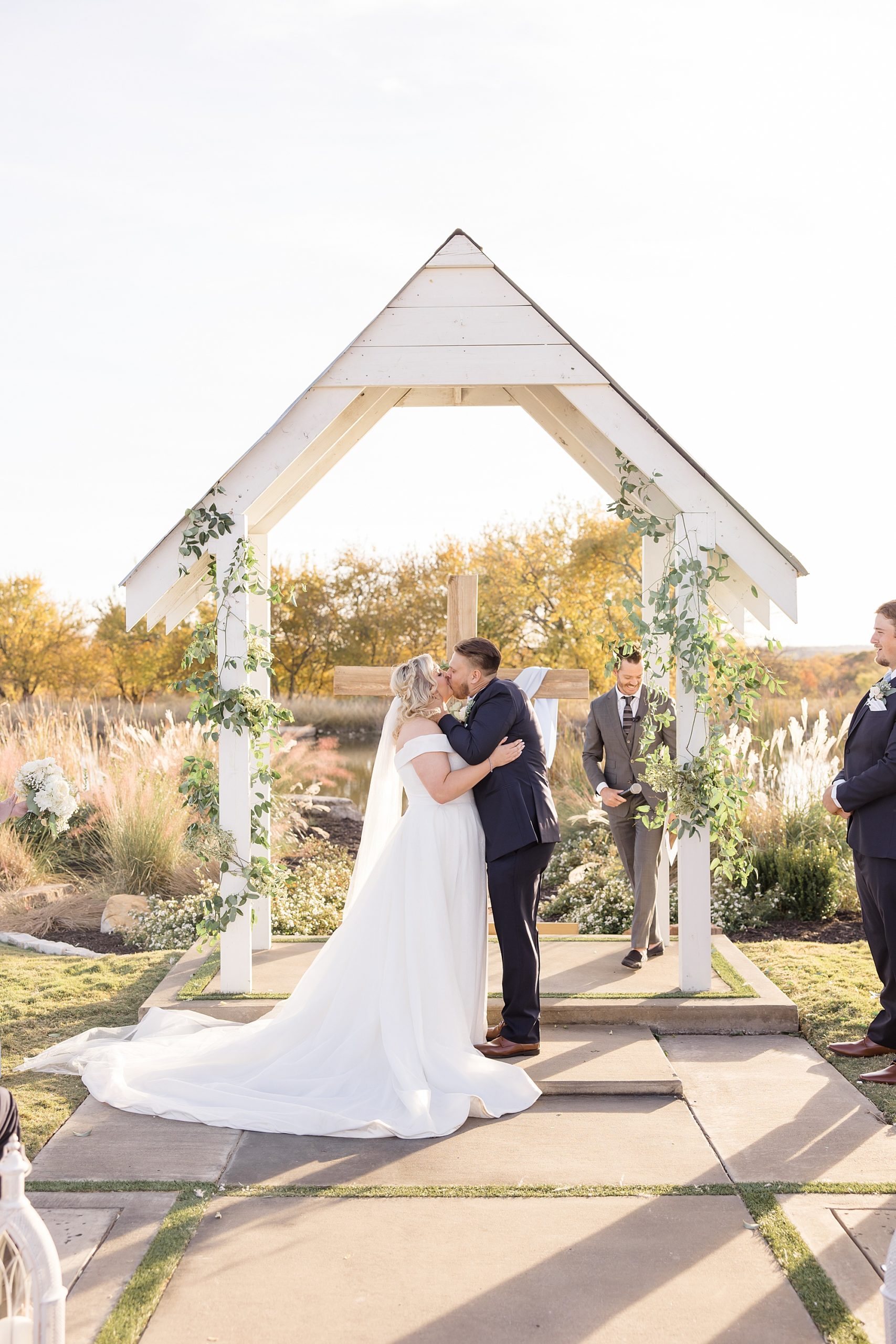 newlyweds kiss during outdoor wedding ceremony in Texas