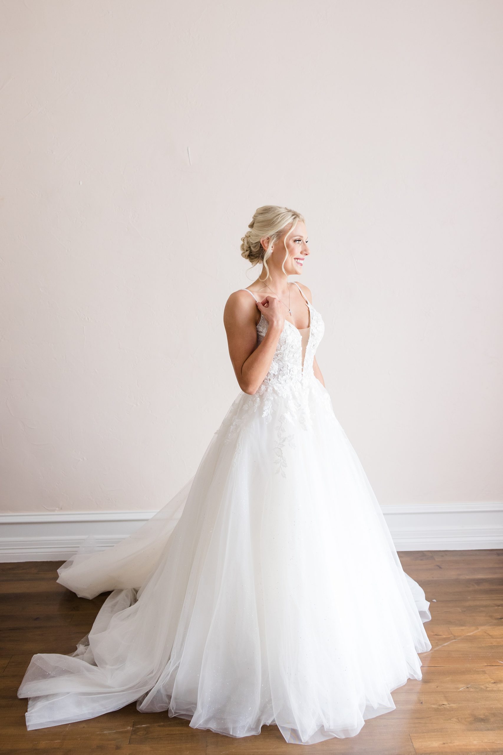 bride stands in bridal suite in wedding gown