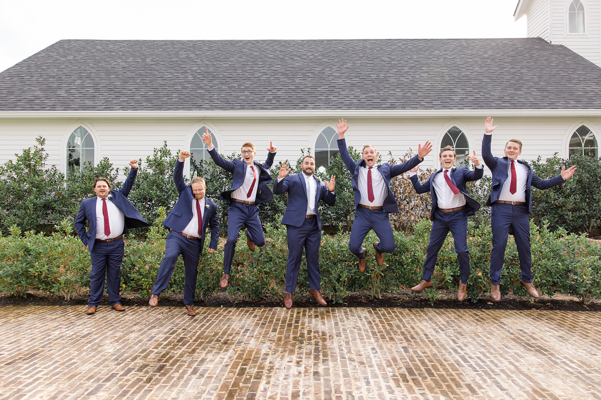 groomsmen jump during photos in Texas