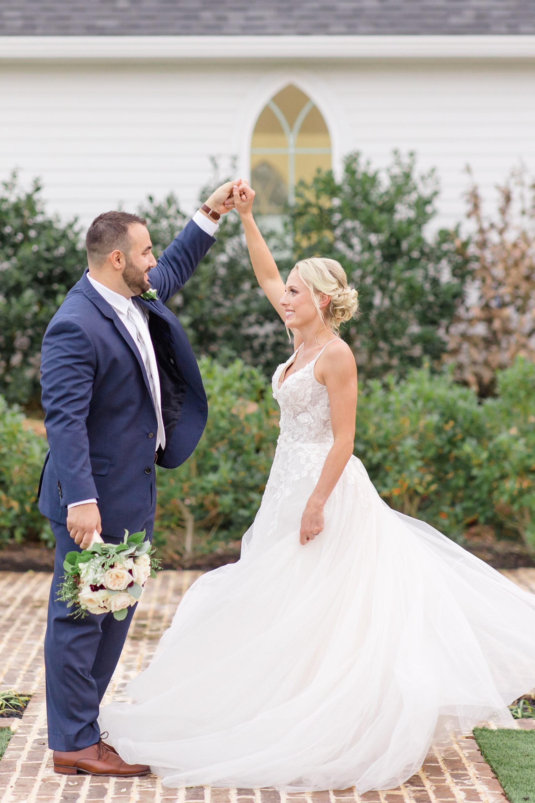 groom twirls bride during wedding photos in Texas