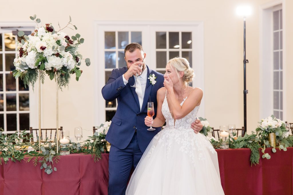 newlyweds laugh together during toasts 