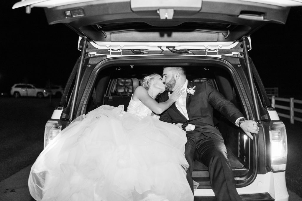 bride and groom kiss during wedding day exit