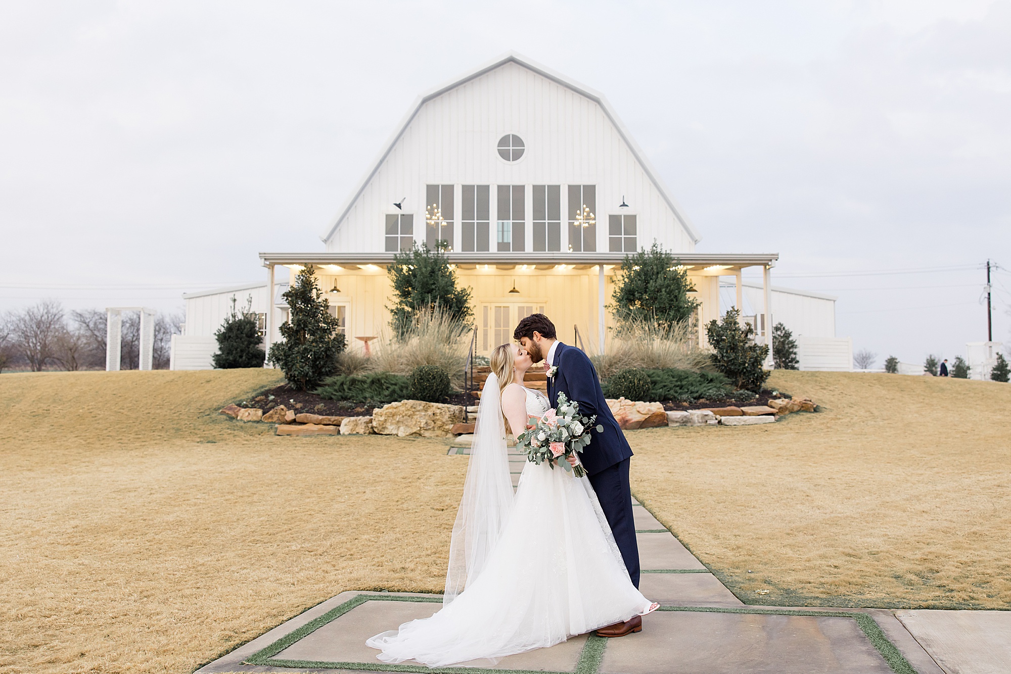 newlyweds kiss outside The Nest at Ruth Farms