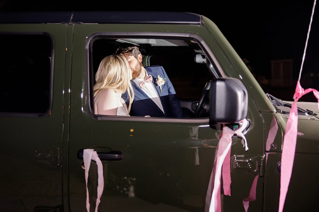 couple kisses in jeep after wedding at The Nest at Ruth Farms