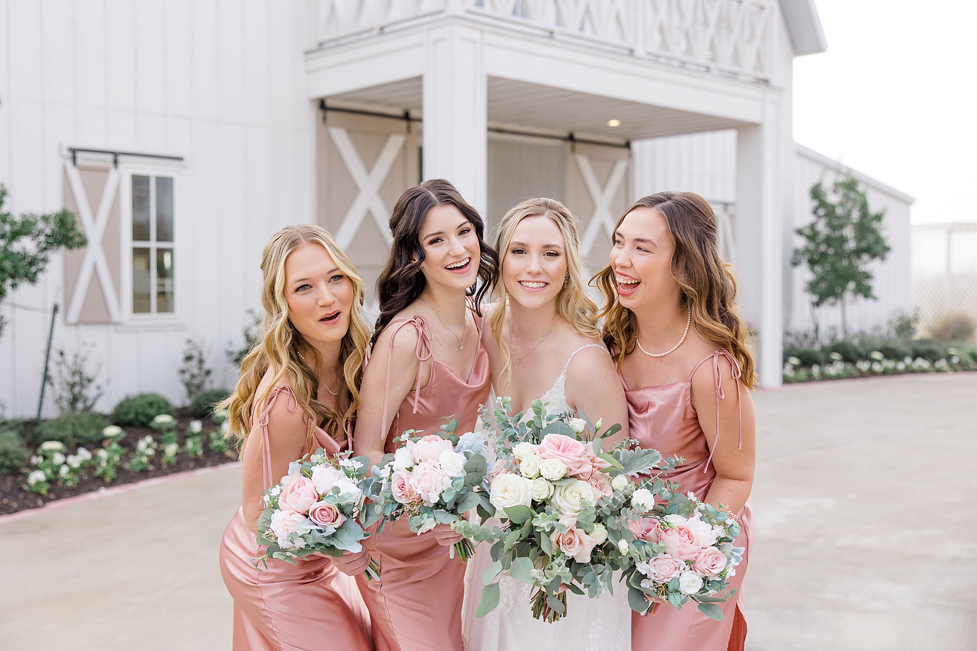 bride laughs with bridesmaids in pink gowns