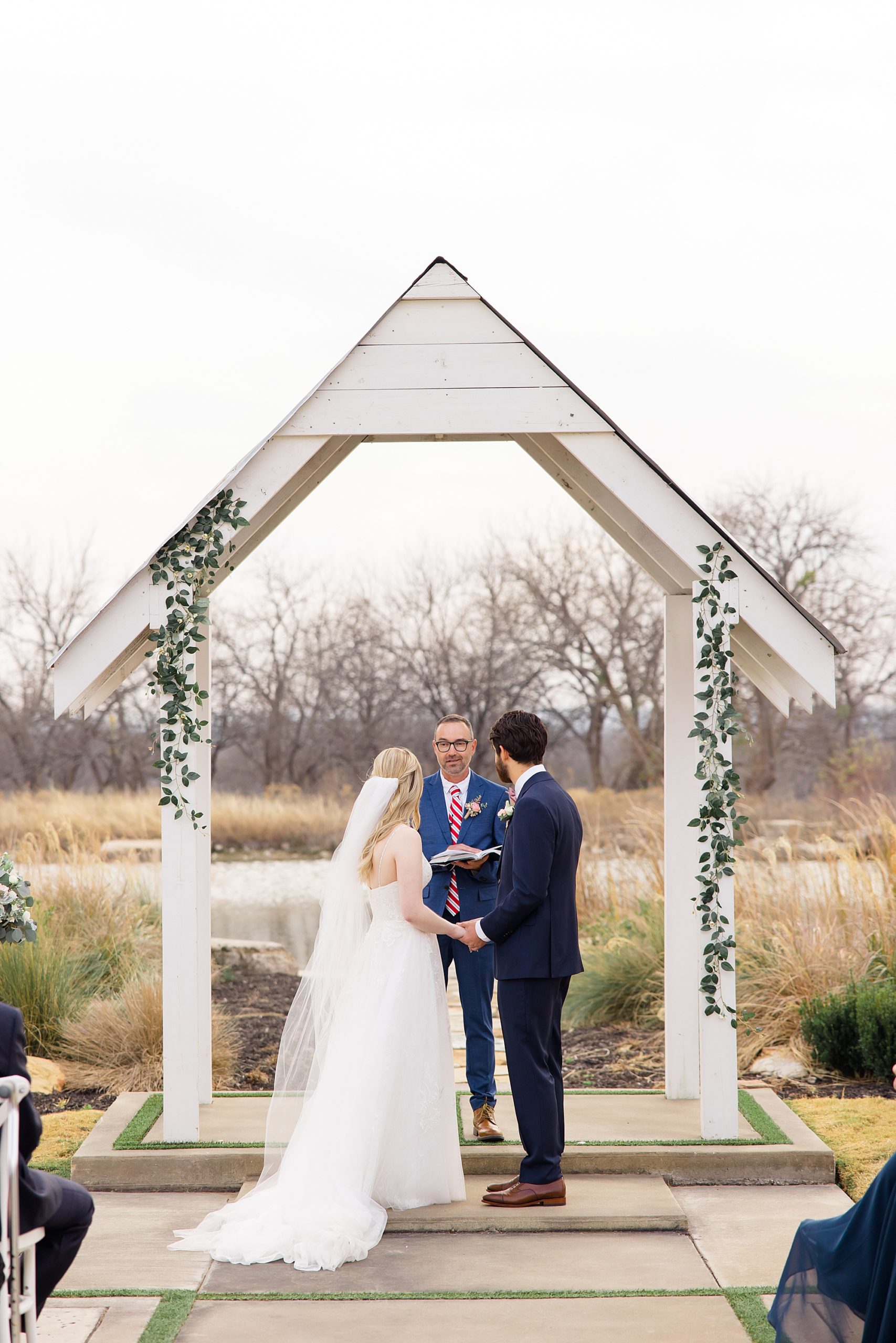 bride and groom exchange vows during outdoor wedding ceremony in the winter