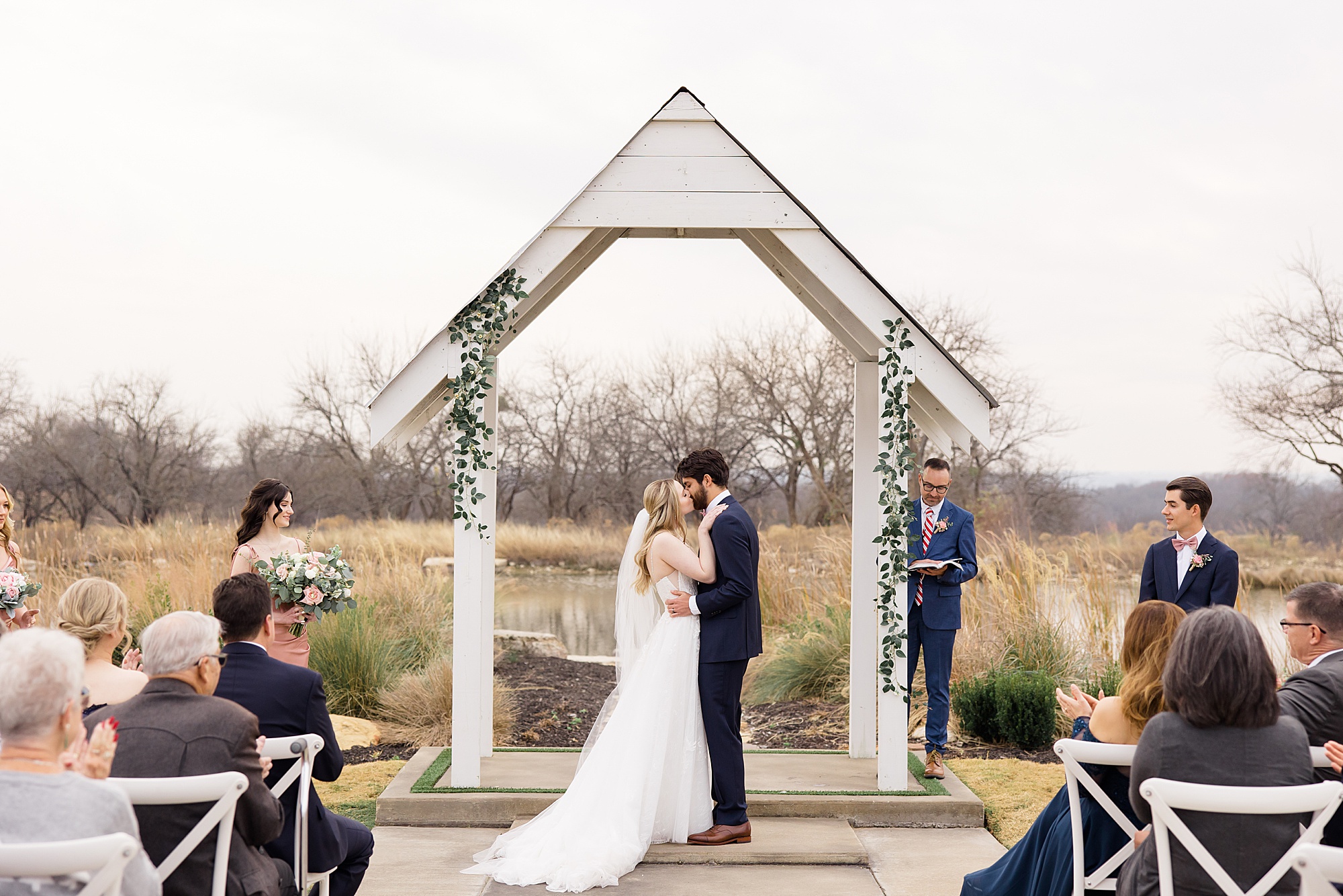 couple kisses during outdoor wedding ceremony in the winter