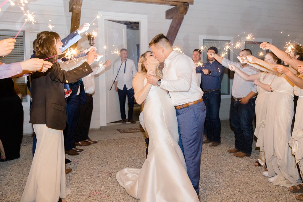 bride and groom kiss during sparkler exit from Rosewell NM wedding reception