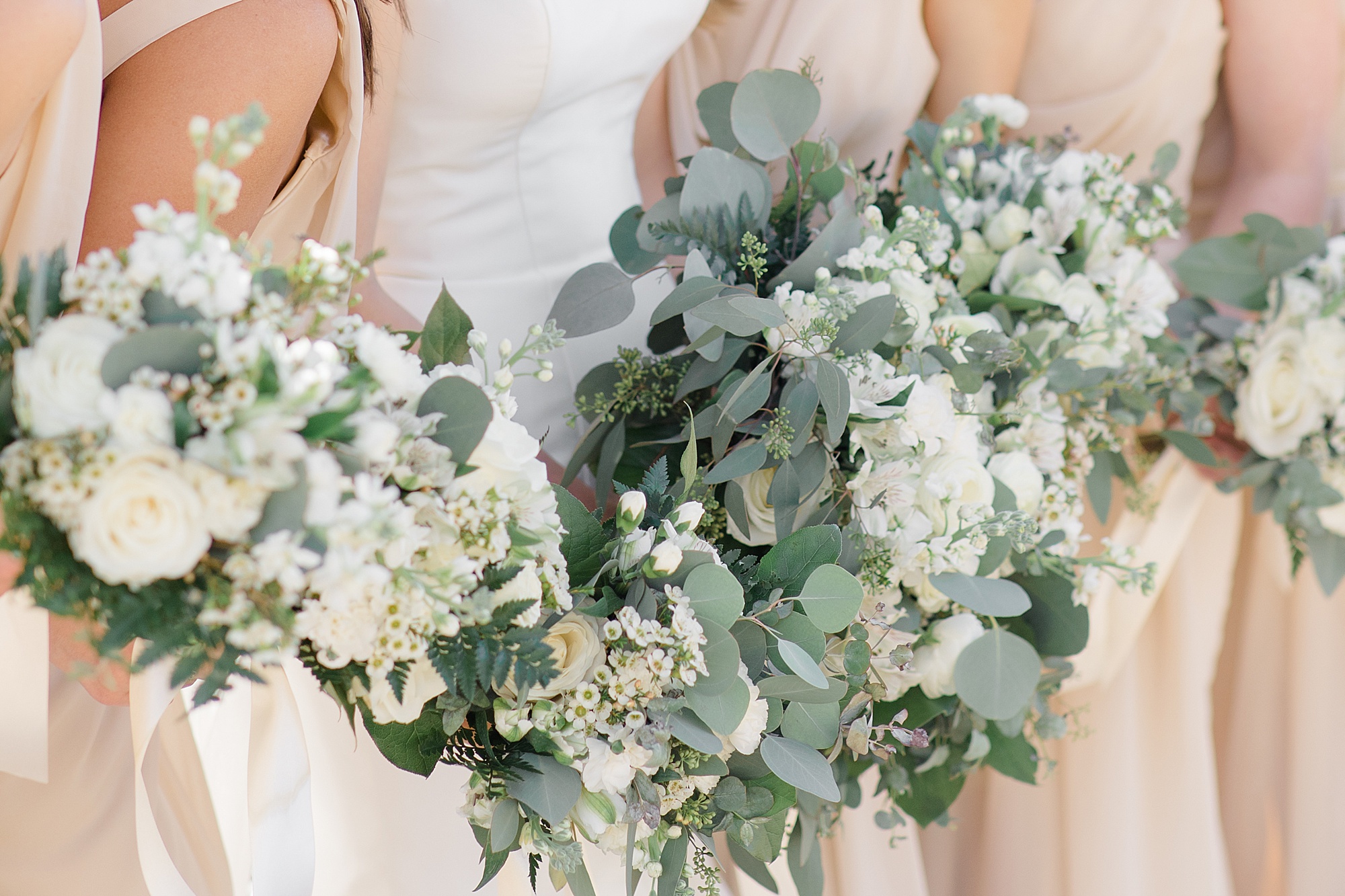 bride and bridesmaids hold white and green bouquets for winter wedding in Rosewell