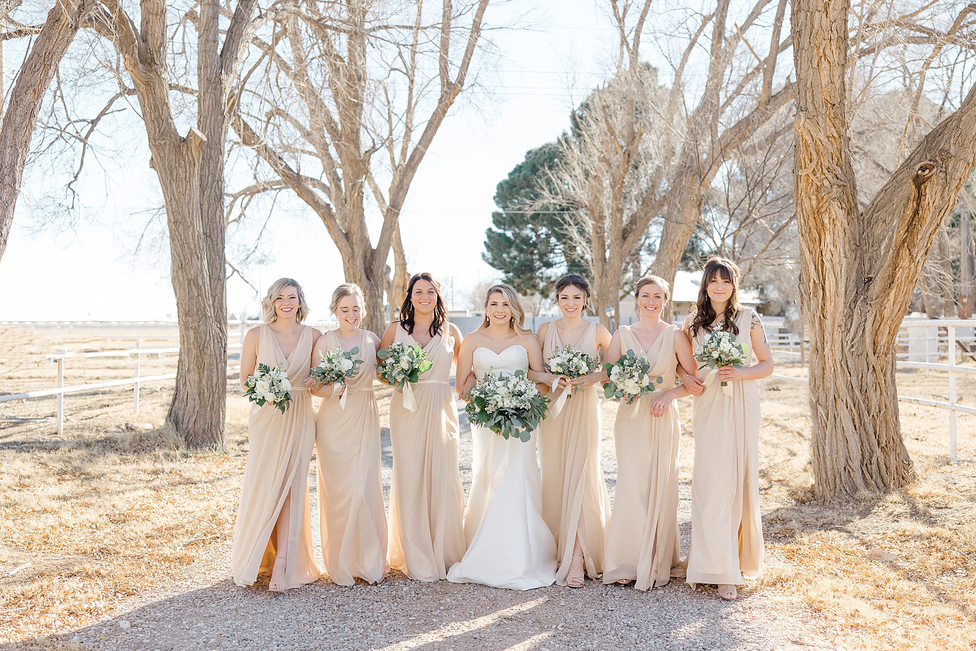 bride walks with bridesmaids in champagne gowns