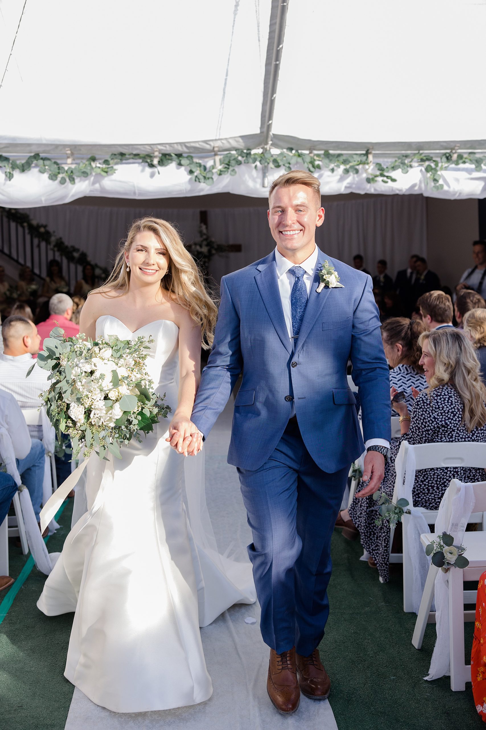 newlyweds walk down aisle after wedding ceremony on private farm in New Mexico