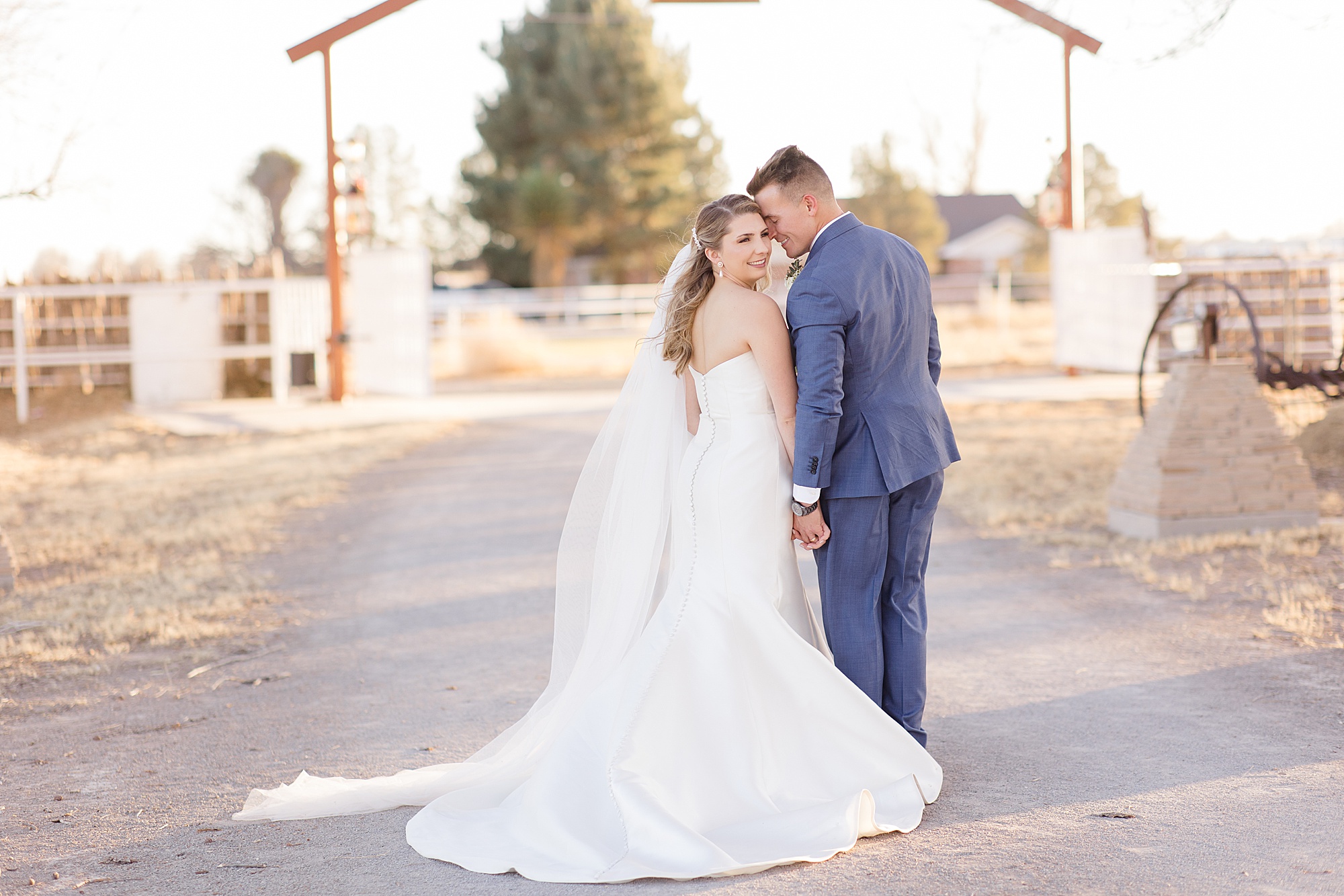 groom nuzzles bride's forehead during portraits on family farm in New Mexico