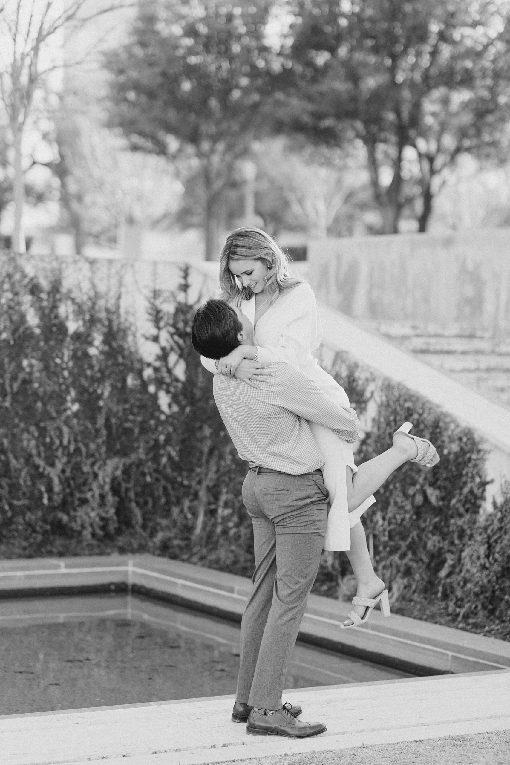 groom lifts bride up during engagement session in Texas
