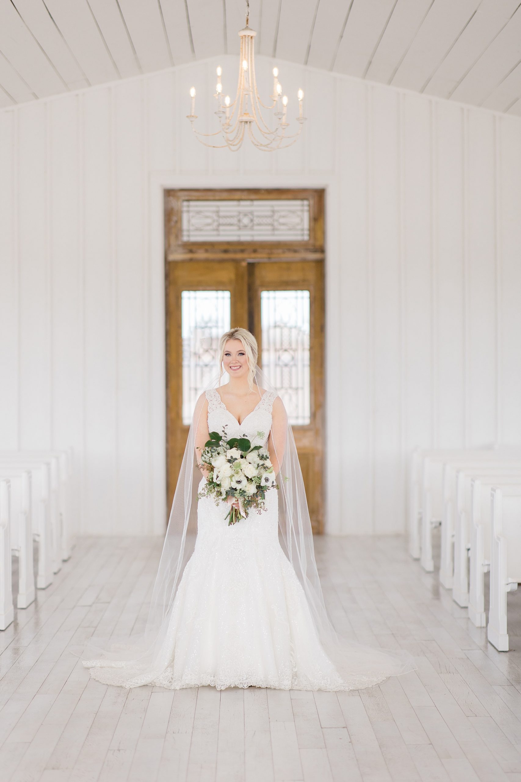 bride stands in chapel at The Grand Ivory with her veil around her shoulders 