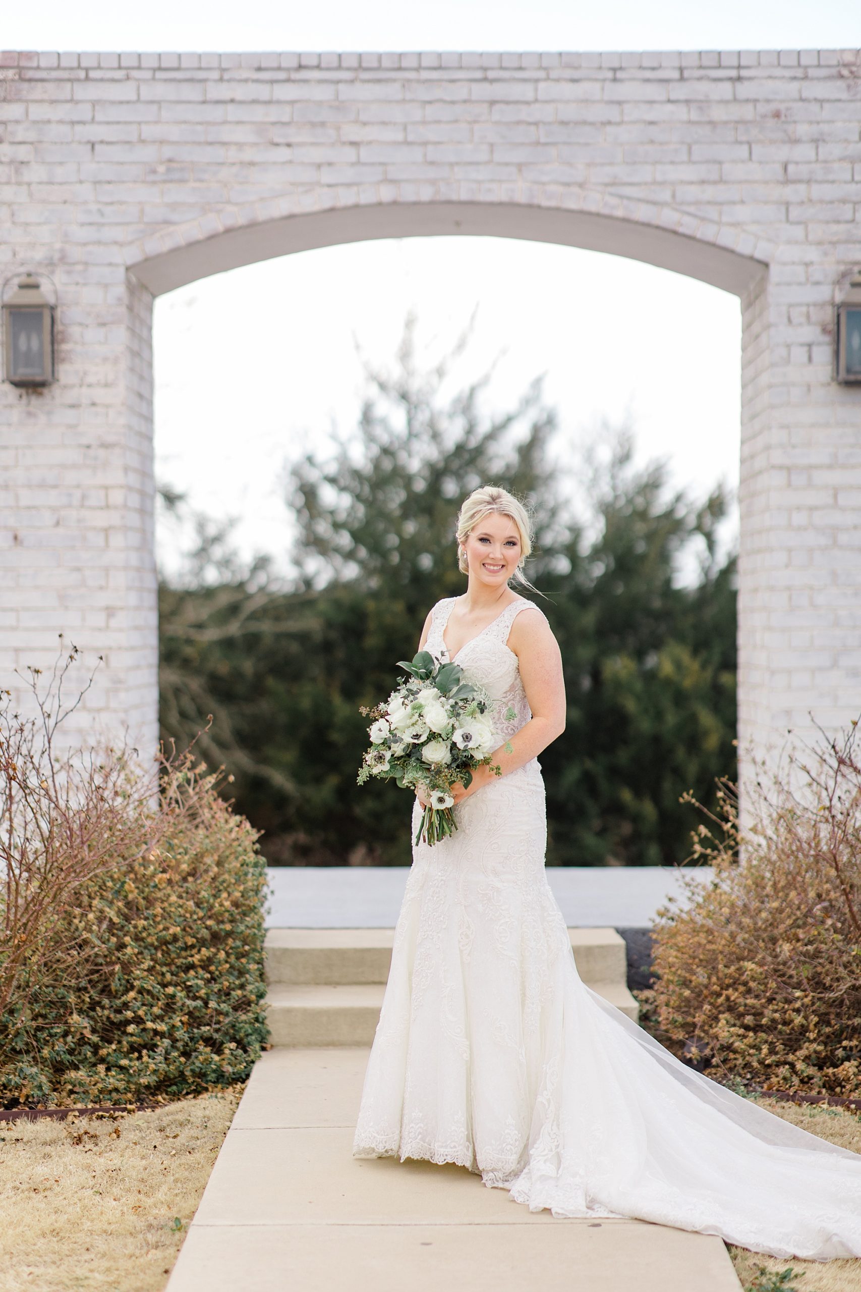 bride poses under stone archway at The Grand Ivory
