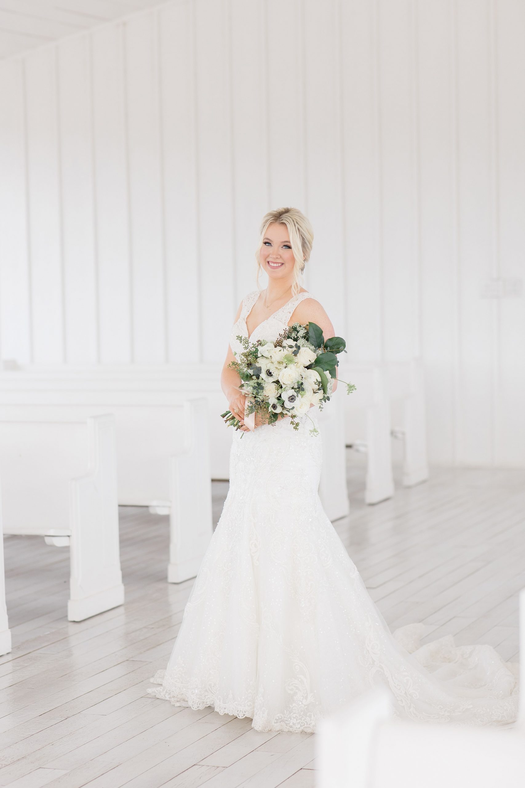 bride poses holding bouquet in chapel at The Grand Ivory