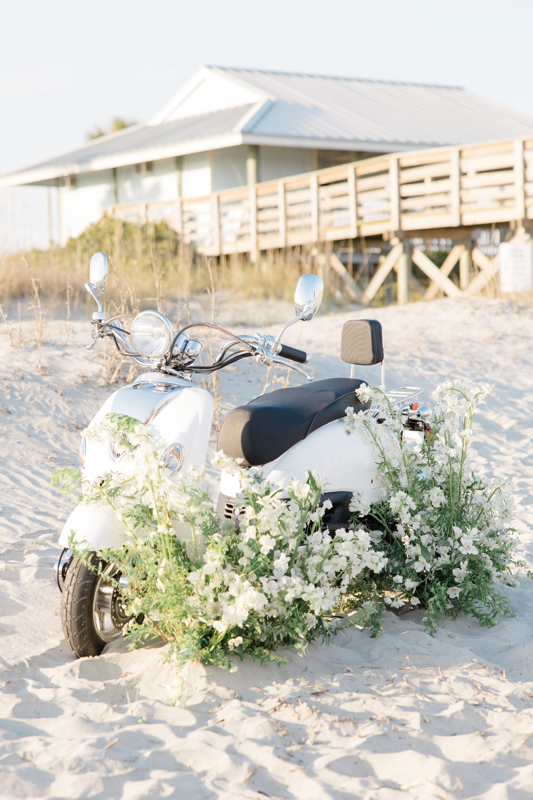 white vespa sits with floral display 