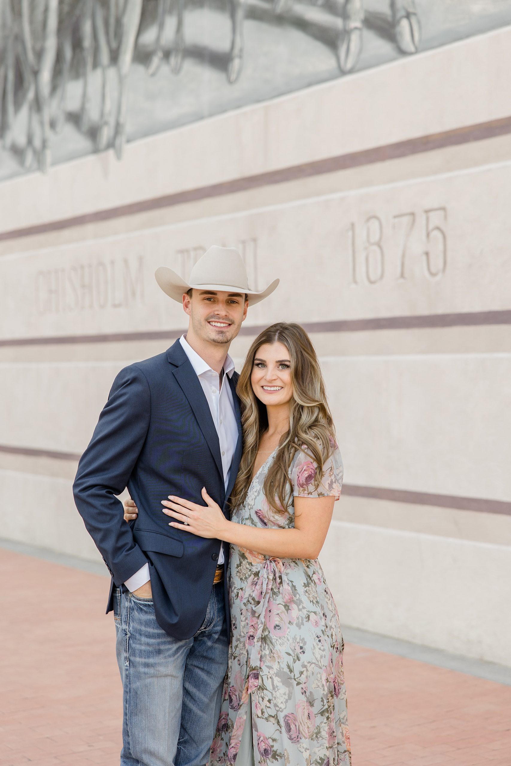 man in cowboy hat hugs fiancee during Fort Worth engagement session
