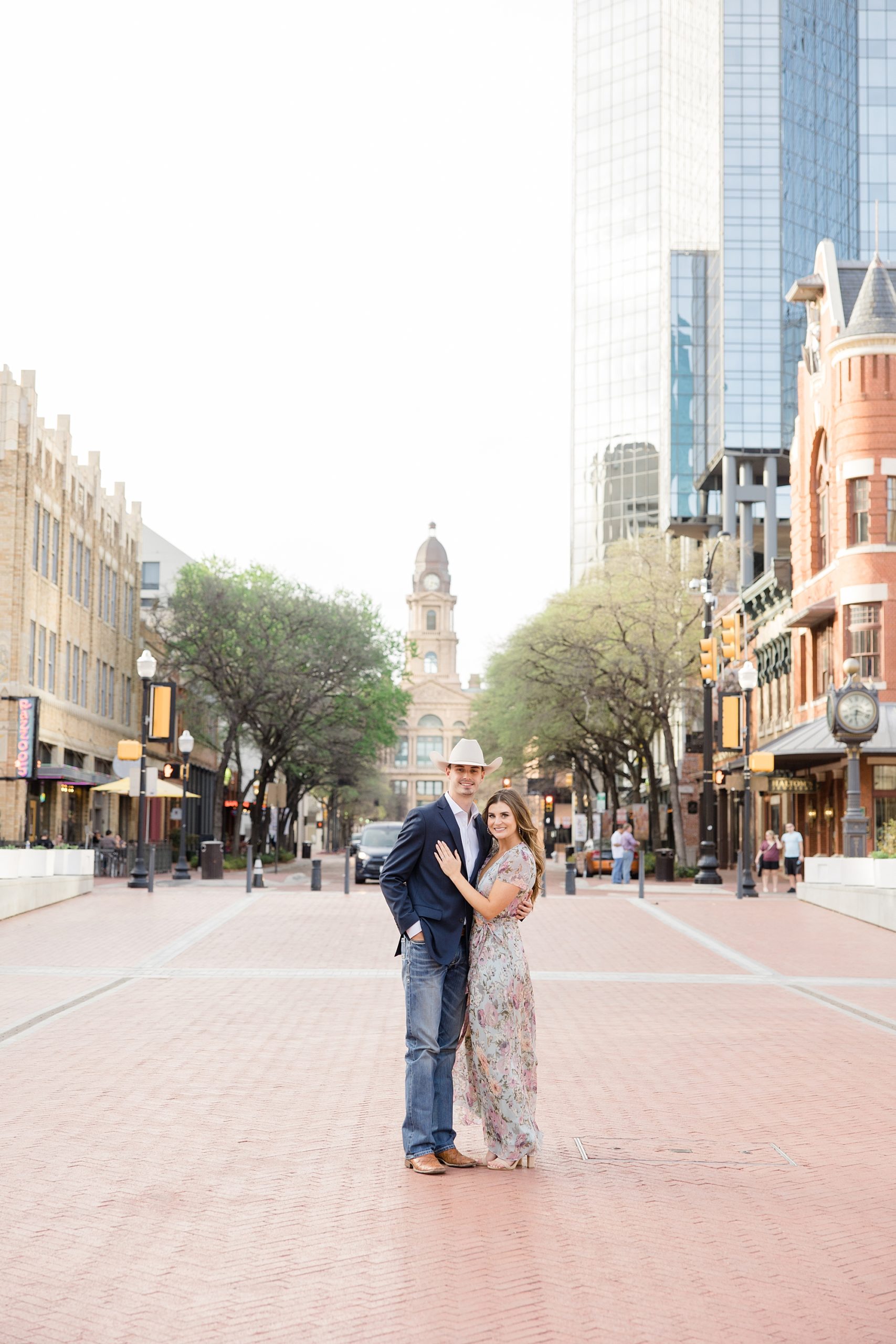 engaged couple poses downtown during engagement photos