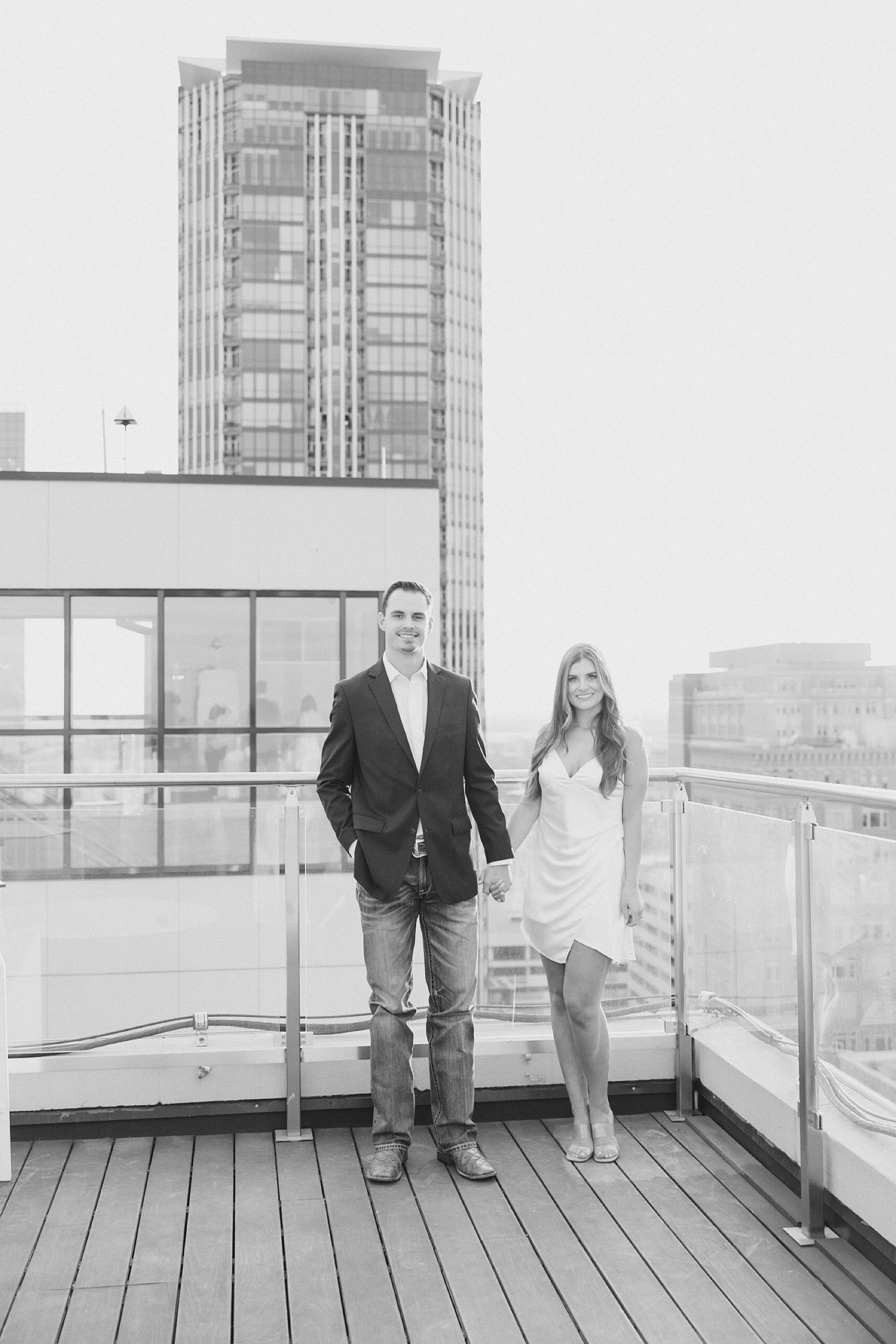 engaged couple walks together on rooftop in Fort Worth