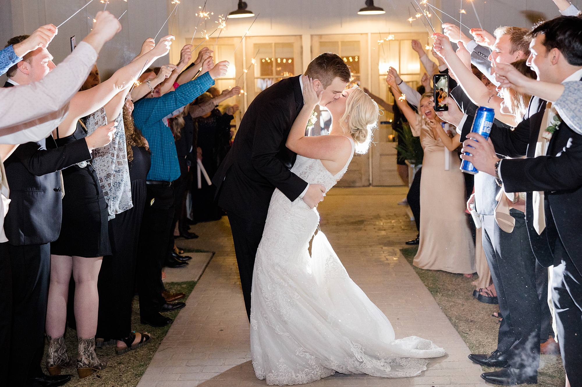 newlyweds kiss during sparkler exit at TX wedding reception