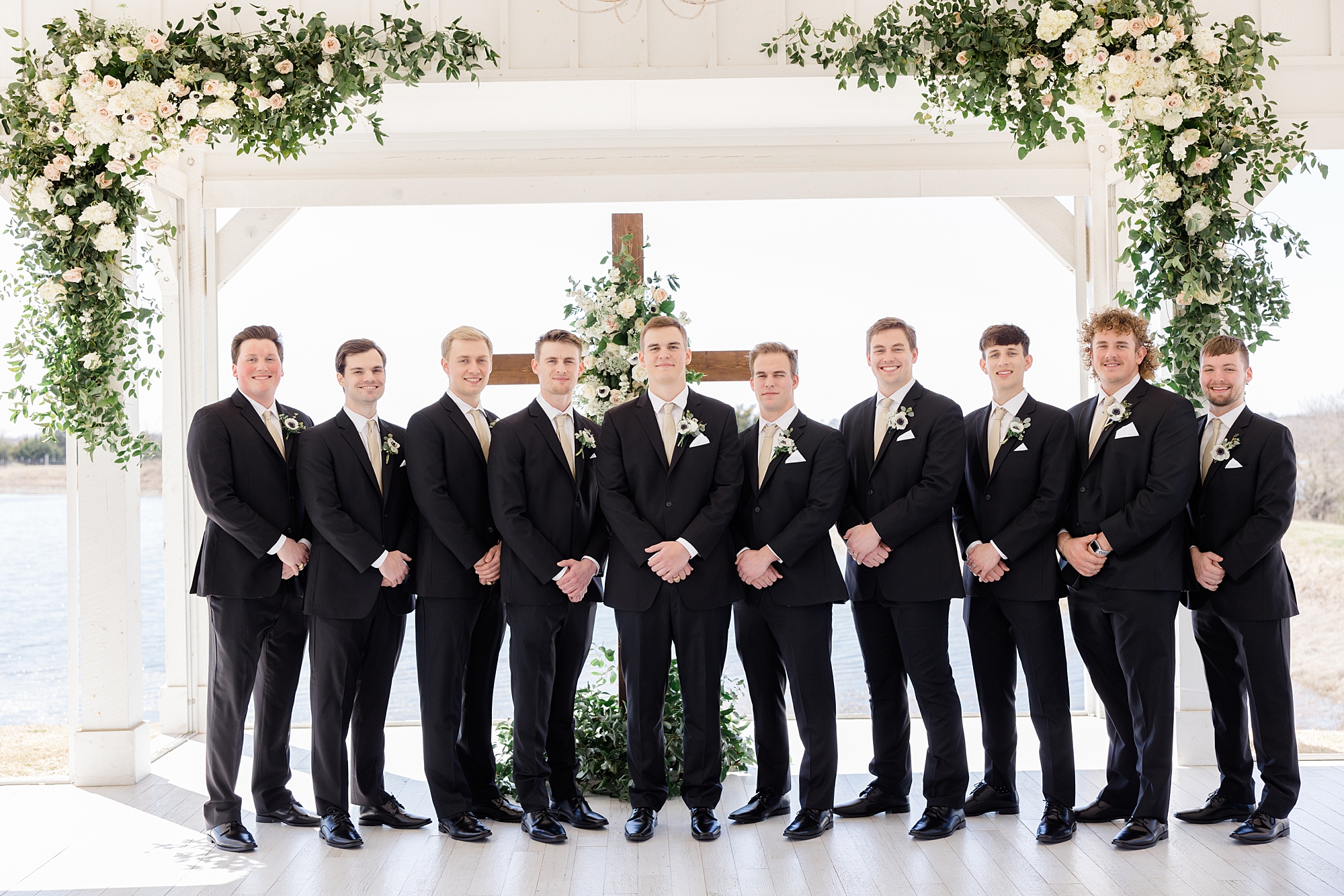 groom and groomsmen stand by ceremony site 