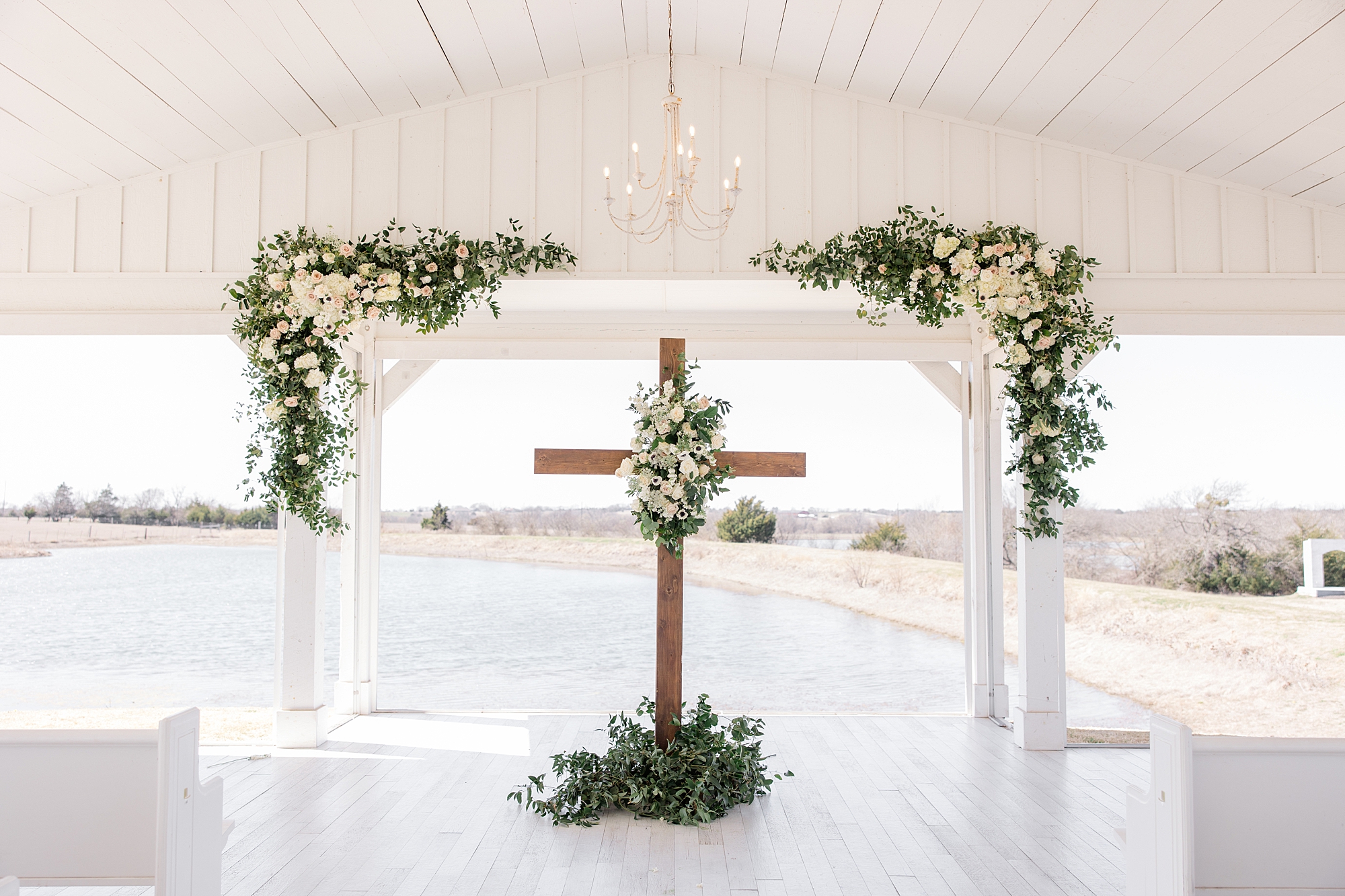wooden cross with white and green floral display for spring wedding at The Grand Ivory