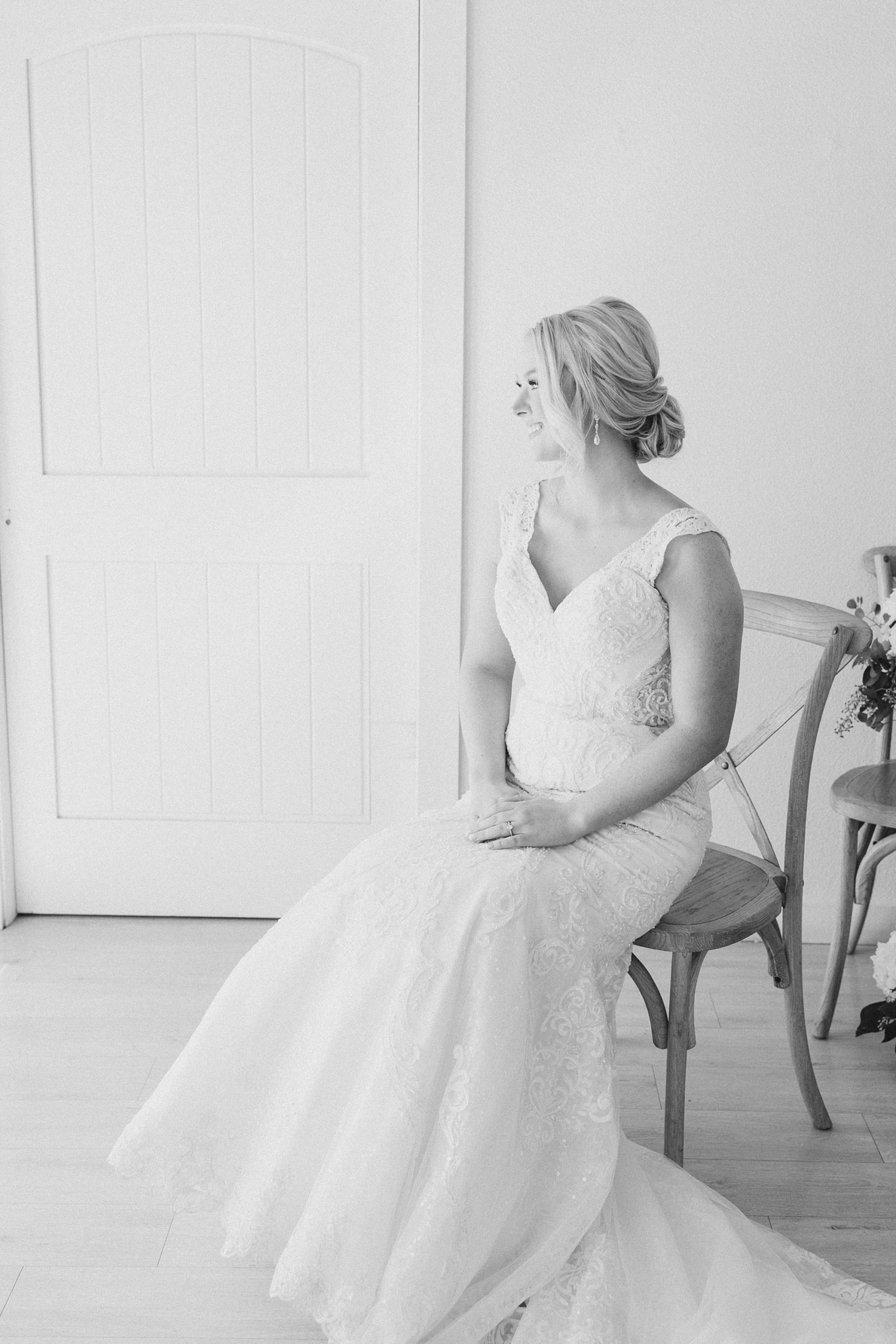 bride sits in wooden chair during bridal portraits in Dallas TX