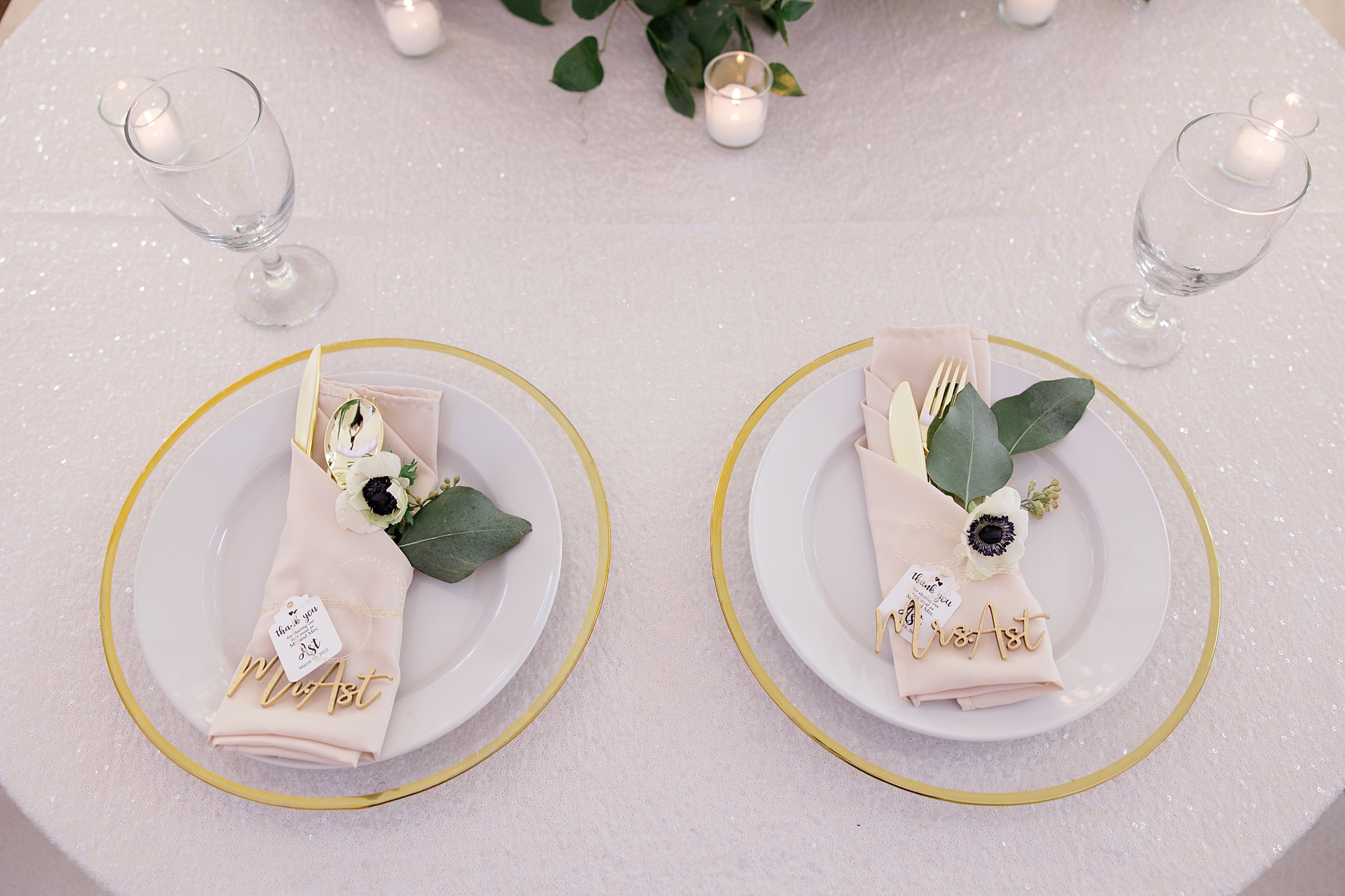 place settings with green leaves and gold rimmed plates