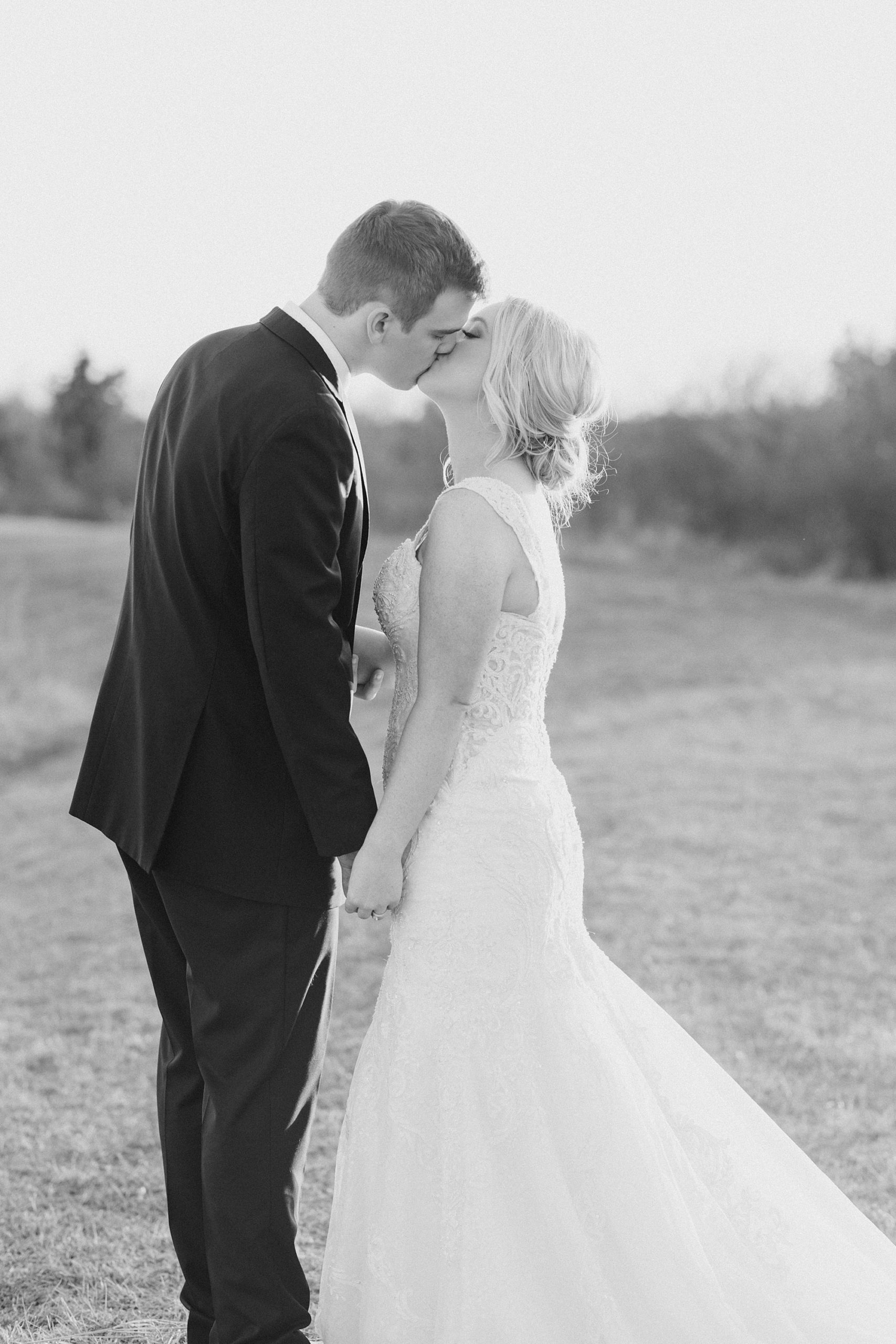 bride and groom kiss during spring wedding portraits at  The Grand Ivory
