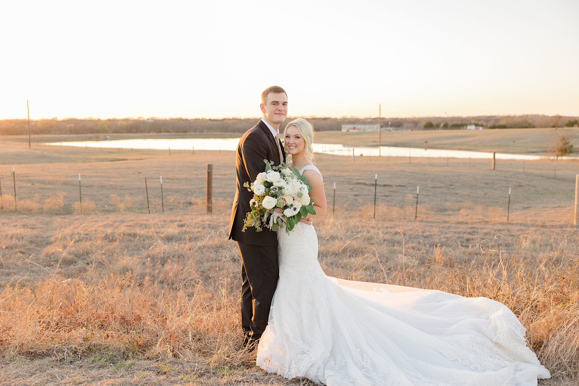 bride and groom hug in field at sunset during TX wedding day