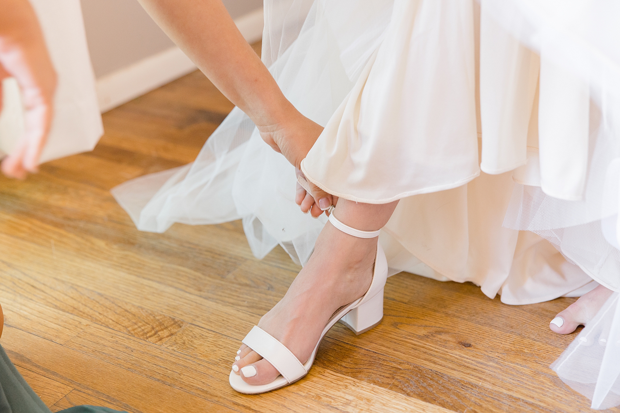 bride adjusts shoes for intimate Sedona wedding day