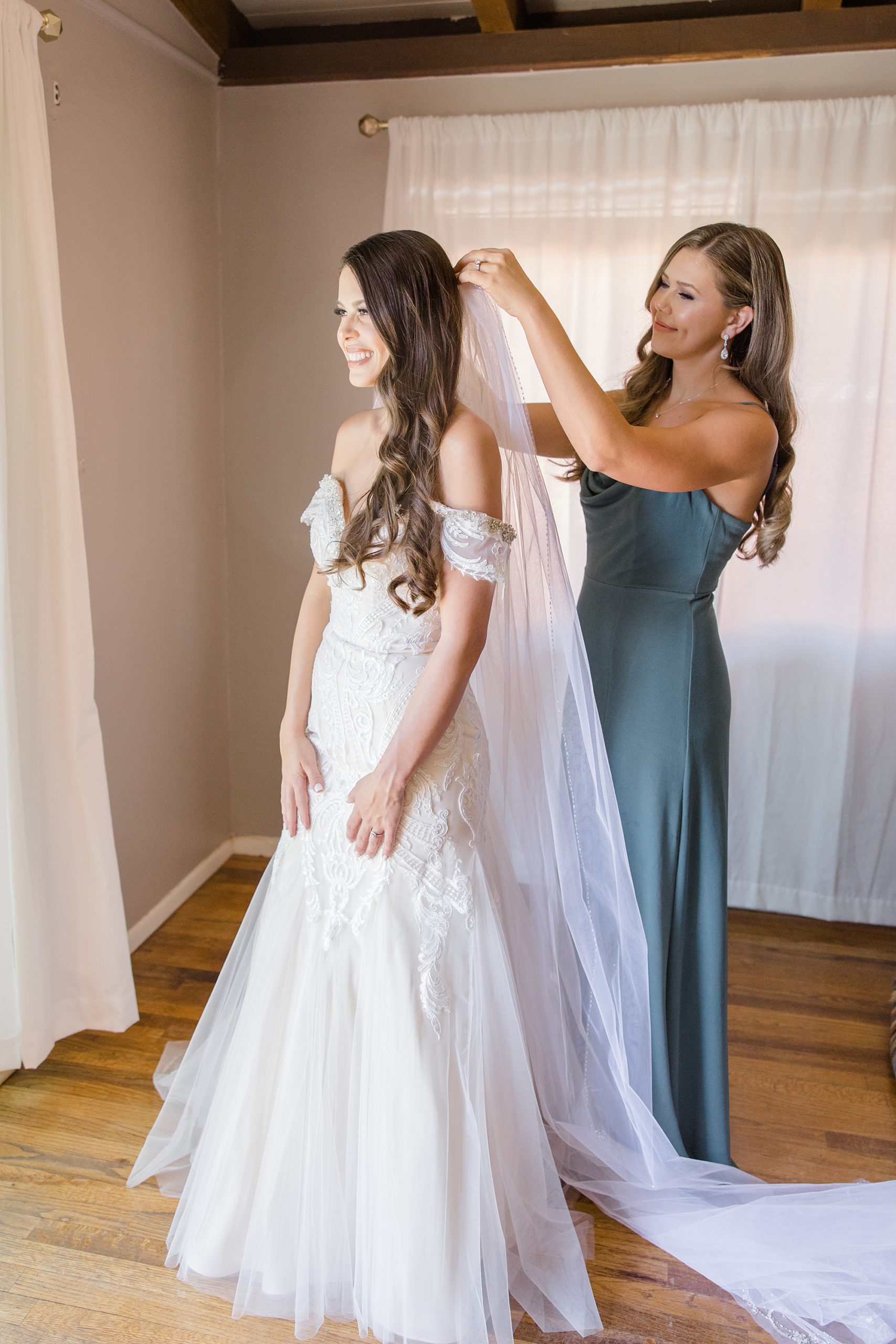 bridesmaid helps bride with veil before intimate Sedona wedding day