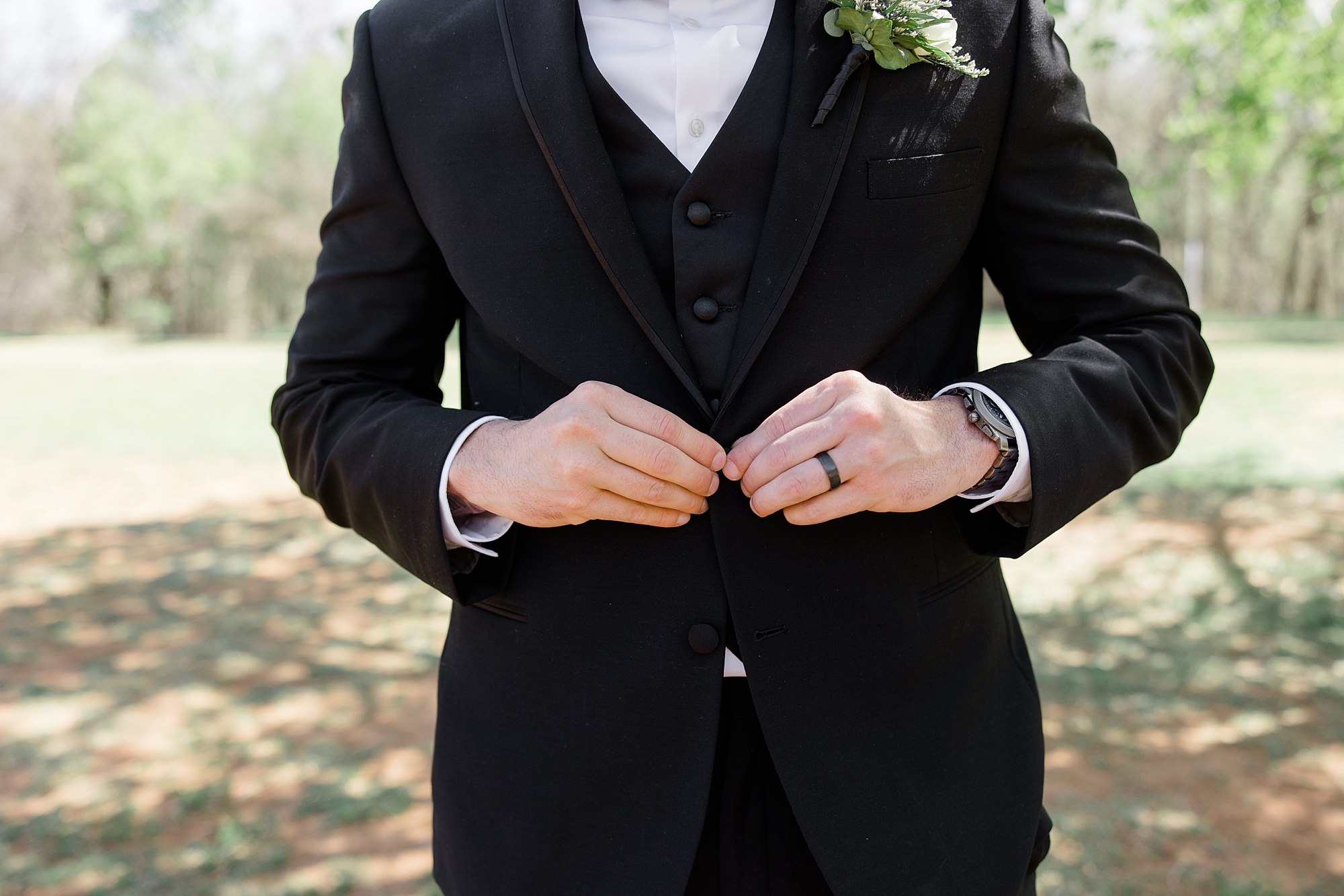 groom buttons jacket during AZ wedding day