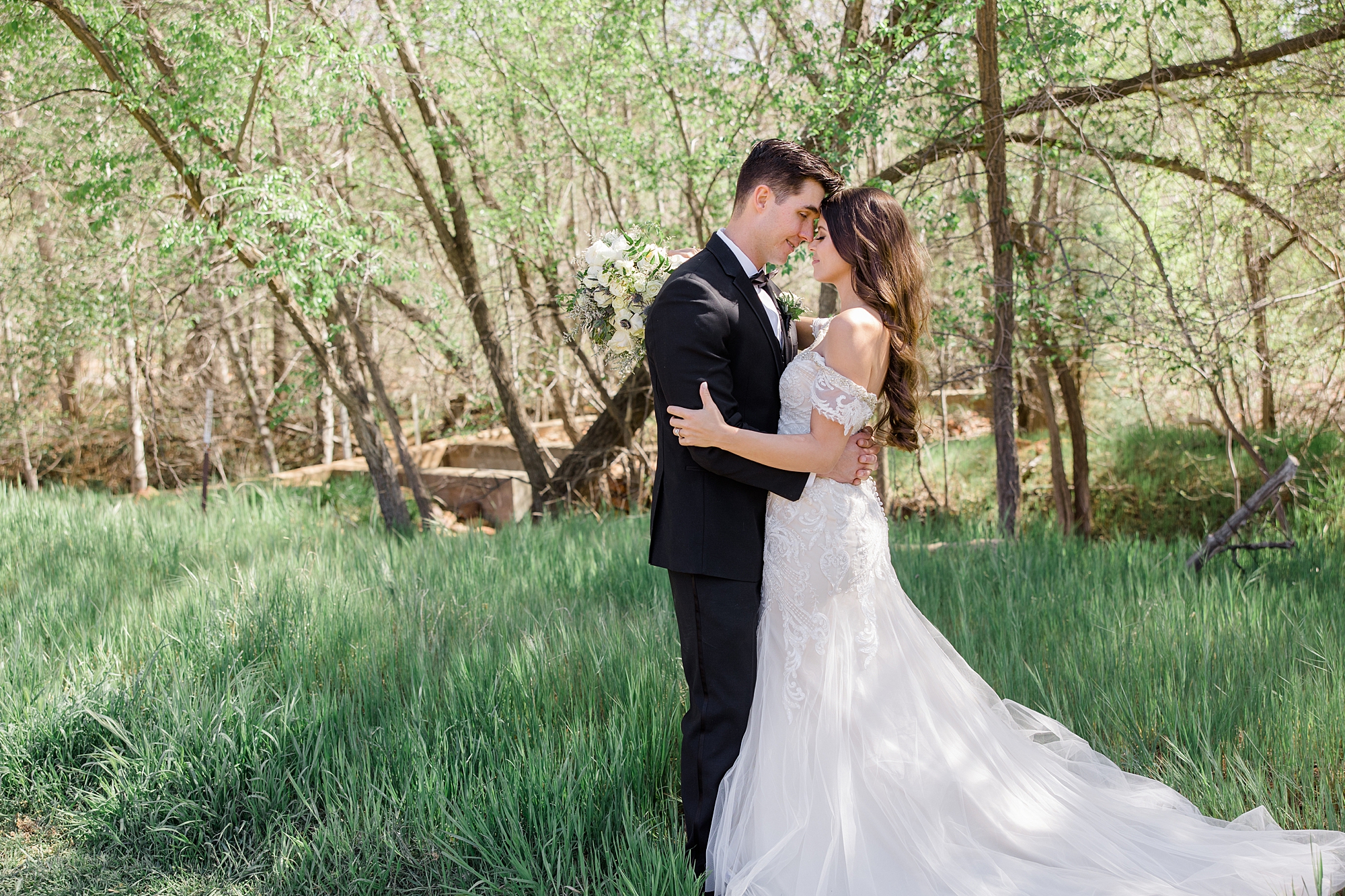 newlyweds kiss in grove of trees