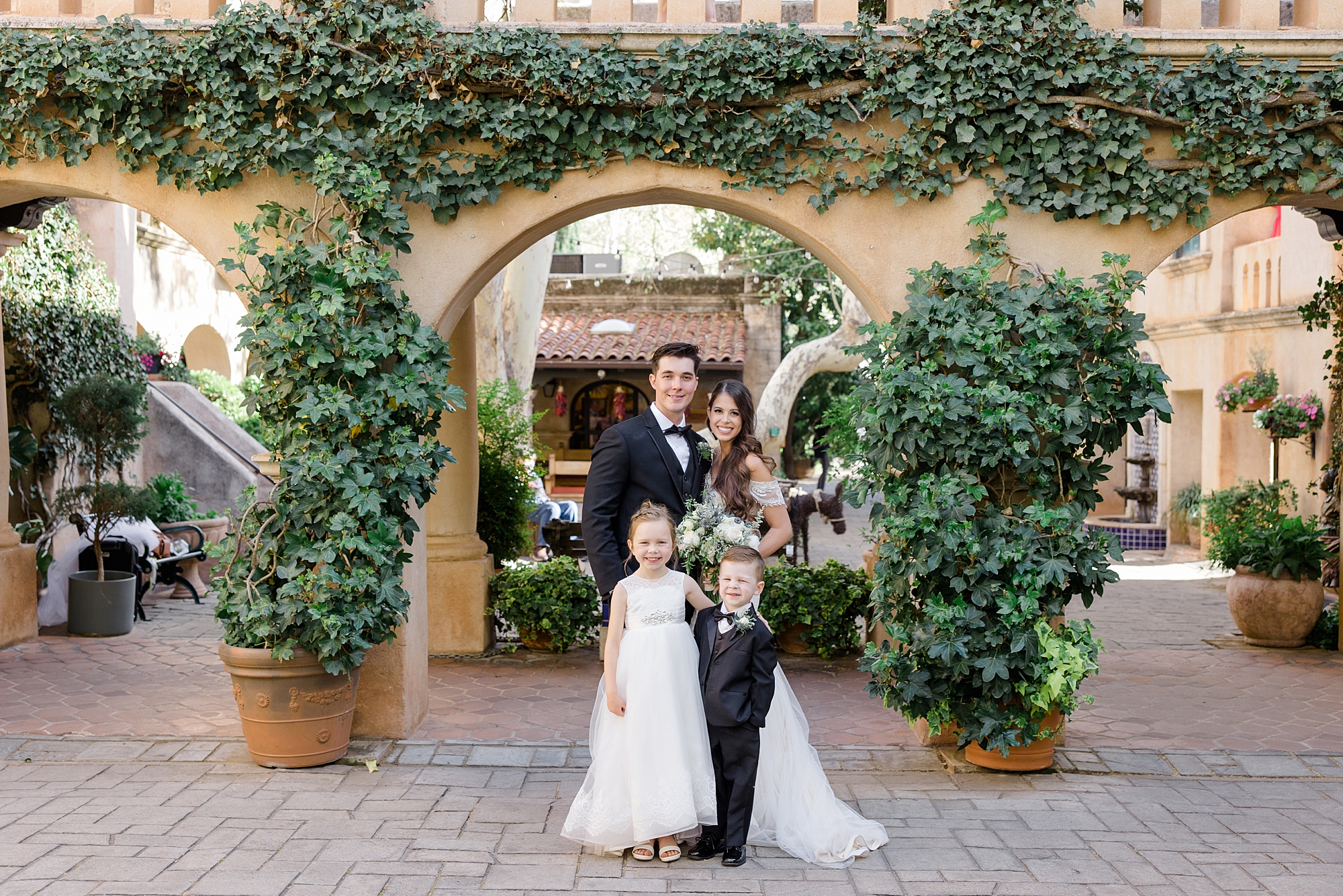 bride and groom pose with flower girl at Tlaquepaque