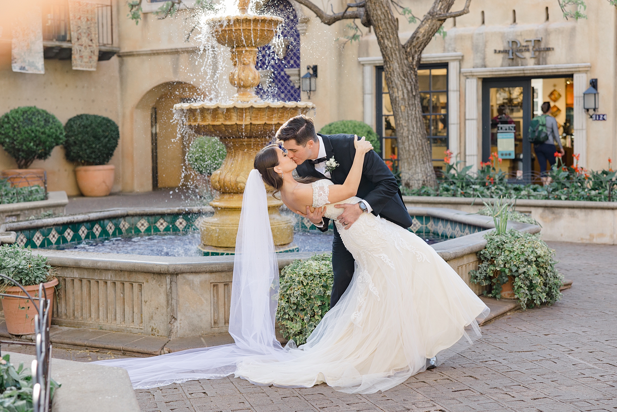 bride and groom kiss dipping outside fountain