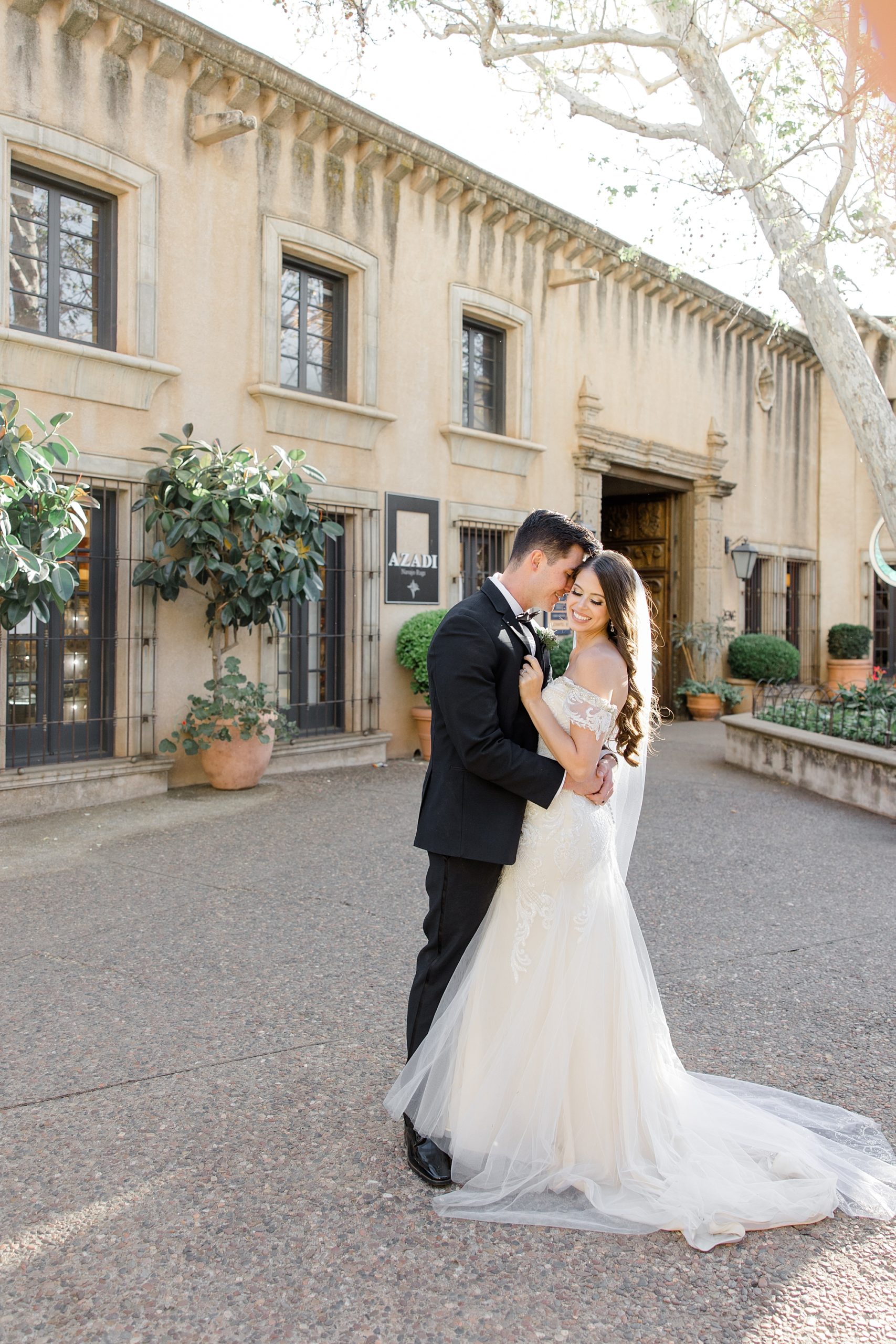 newlyweds kiss in courtyard at Tlaquepaque