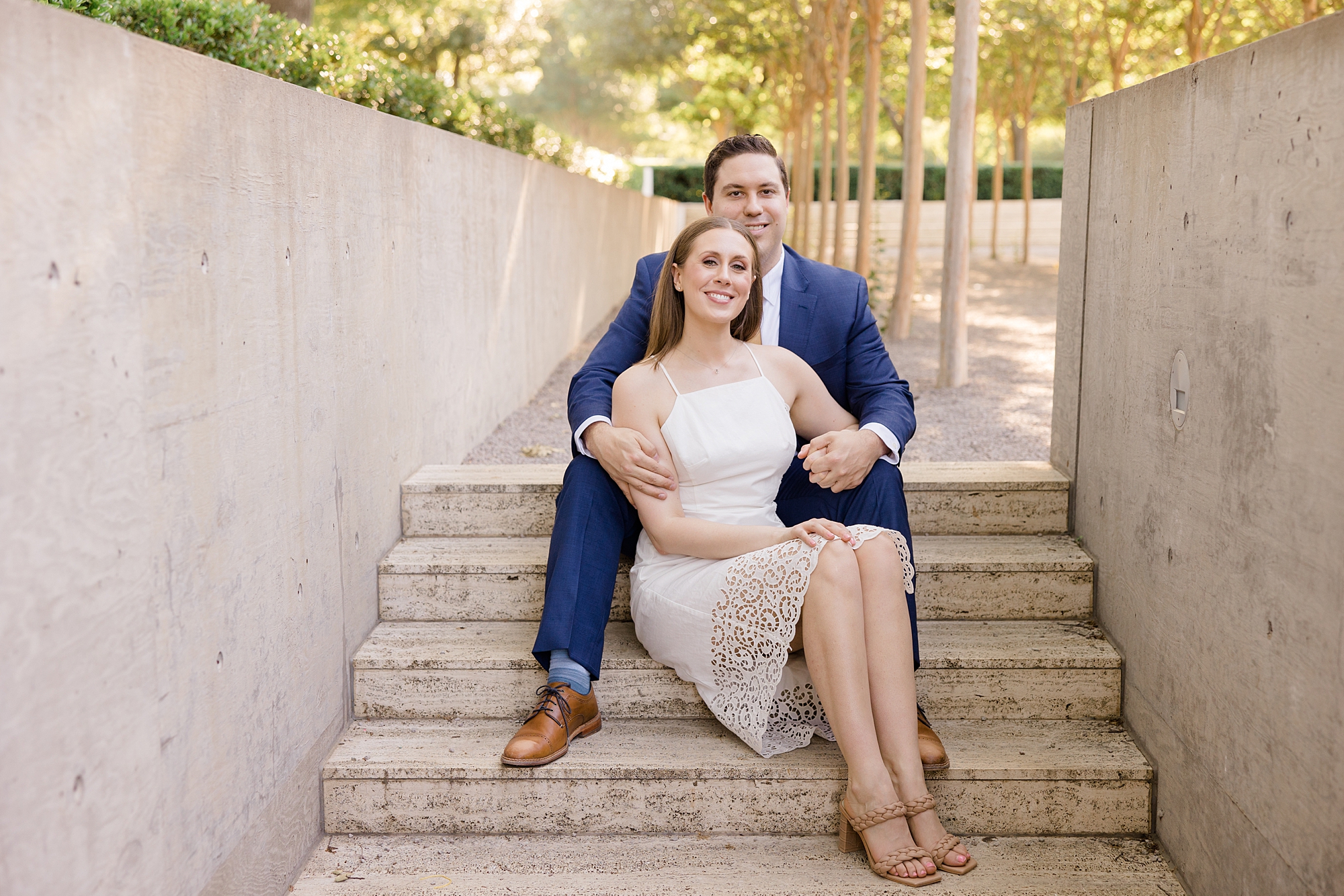 engaged couple sits together on steps during spring Kimball Art Center engagement session