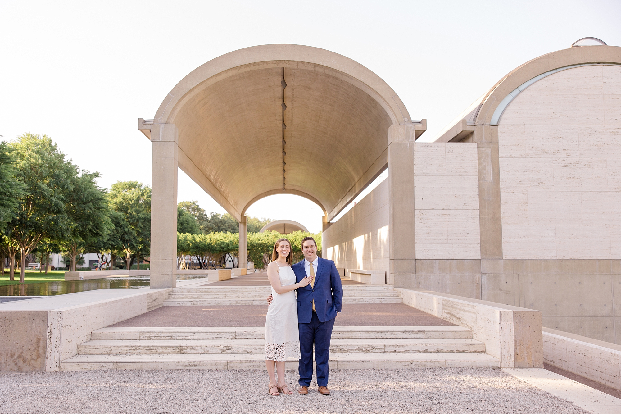 engaged couple stands on steps at Kimball Art Center