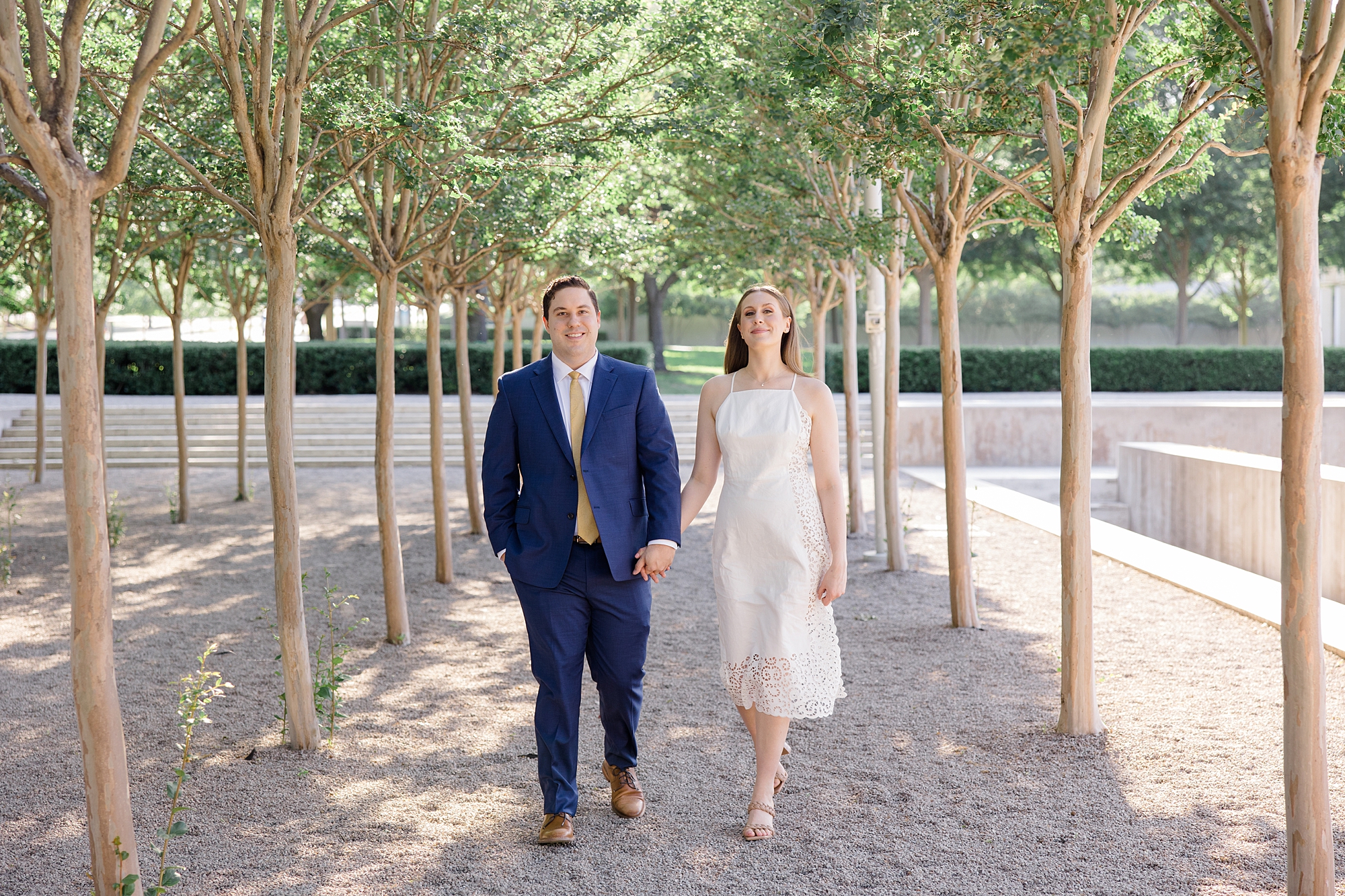 couple holds hands walking together during TX engagement photos