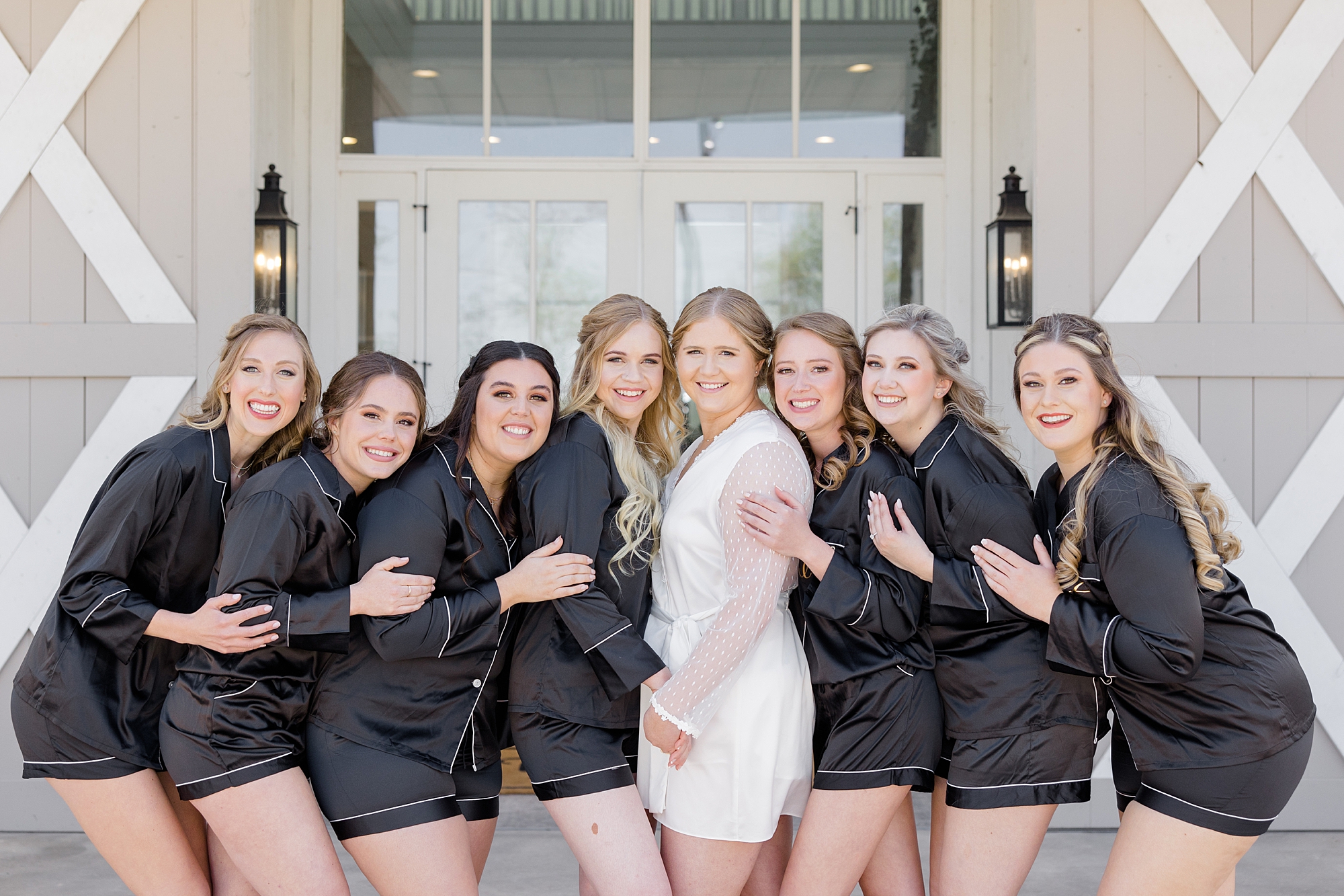 bride and bridesmaids pose together outside  the Nest at Ruth Farms