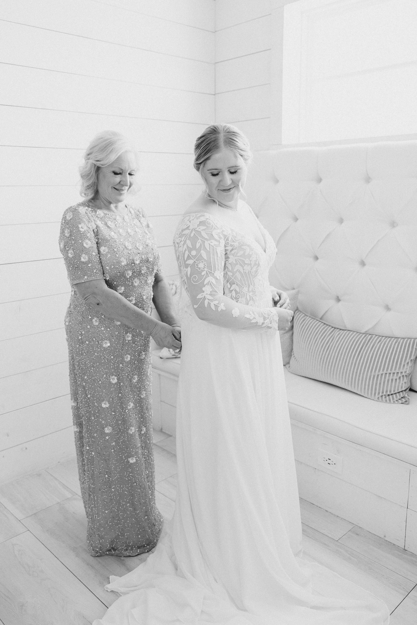 mother helps bride with wedding gown before spring wedding at  the Nest at Ruth Farms