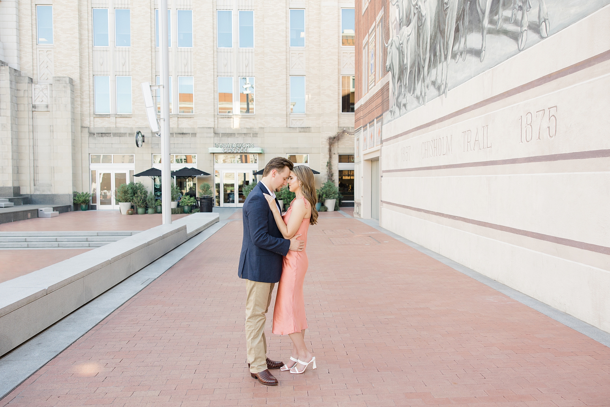 couple stands together on sidewalk in Fort Worth hugging