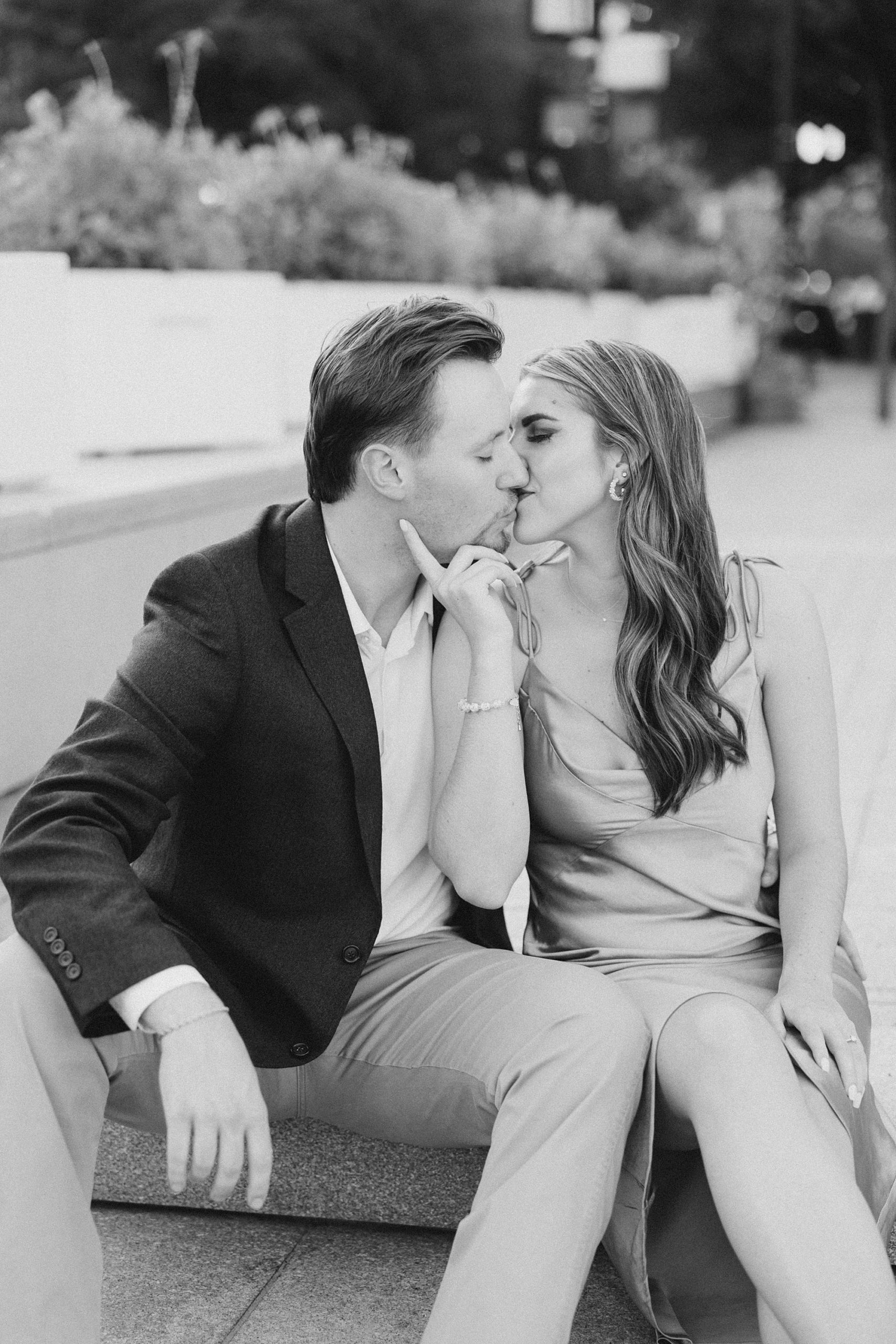 engaged couple kisses on staircase during Sundance Square engagement photos