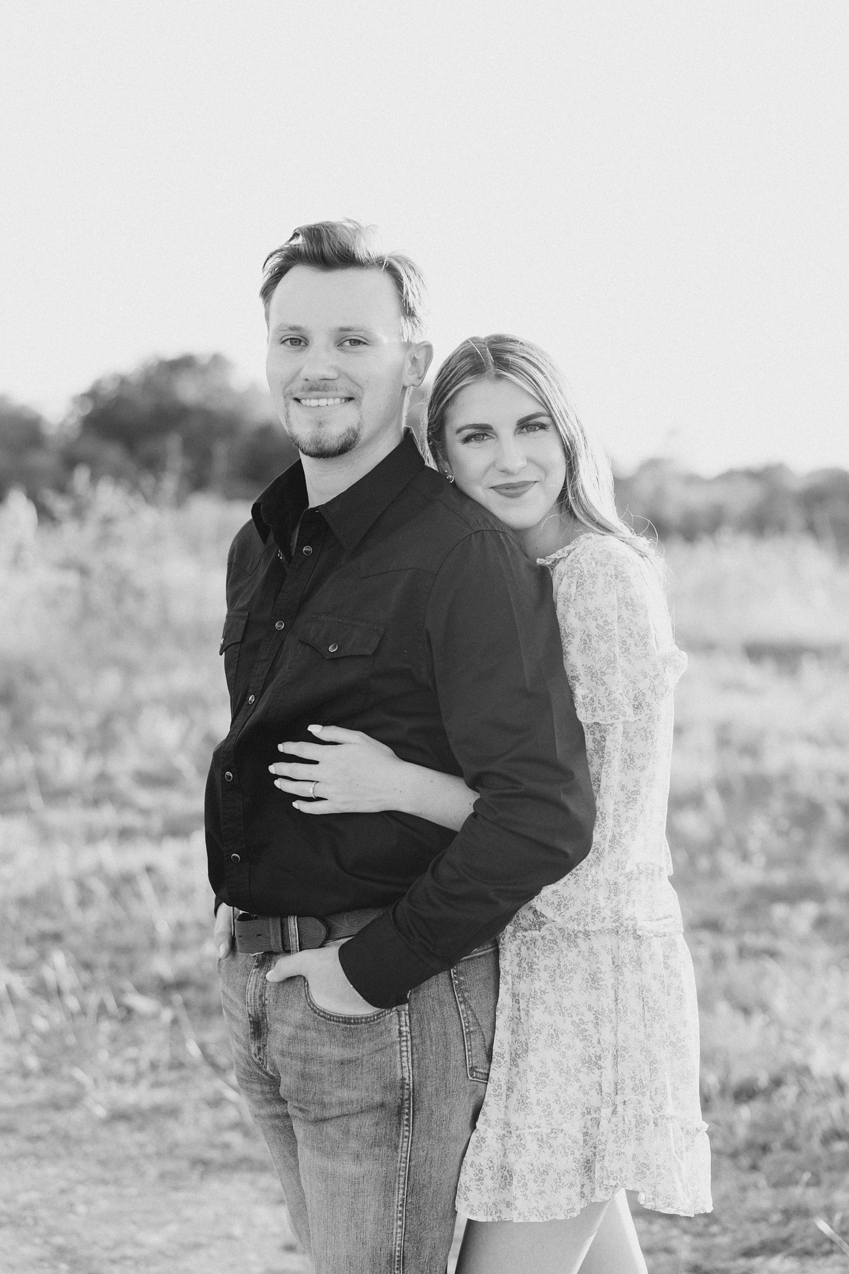 woman hugs man from behind during Fort Worth TX engagement session